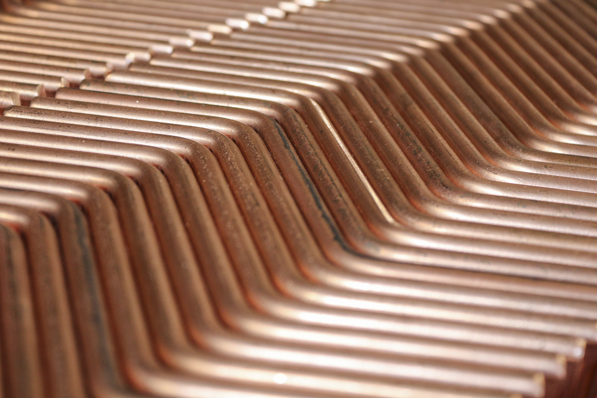 Close-up of multiple copper computer heatsink fins arranged in parallel.