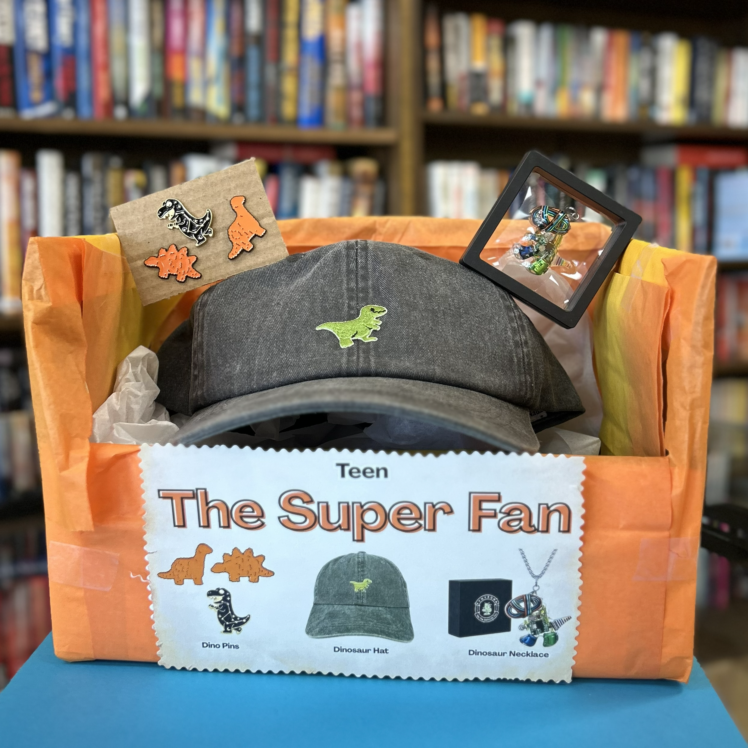 Teen Super Fan bundle includes dinosaur enamel pins, dinosaur hat, and T. Rex necklace