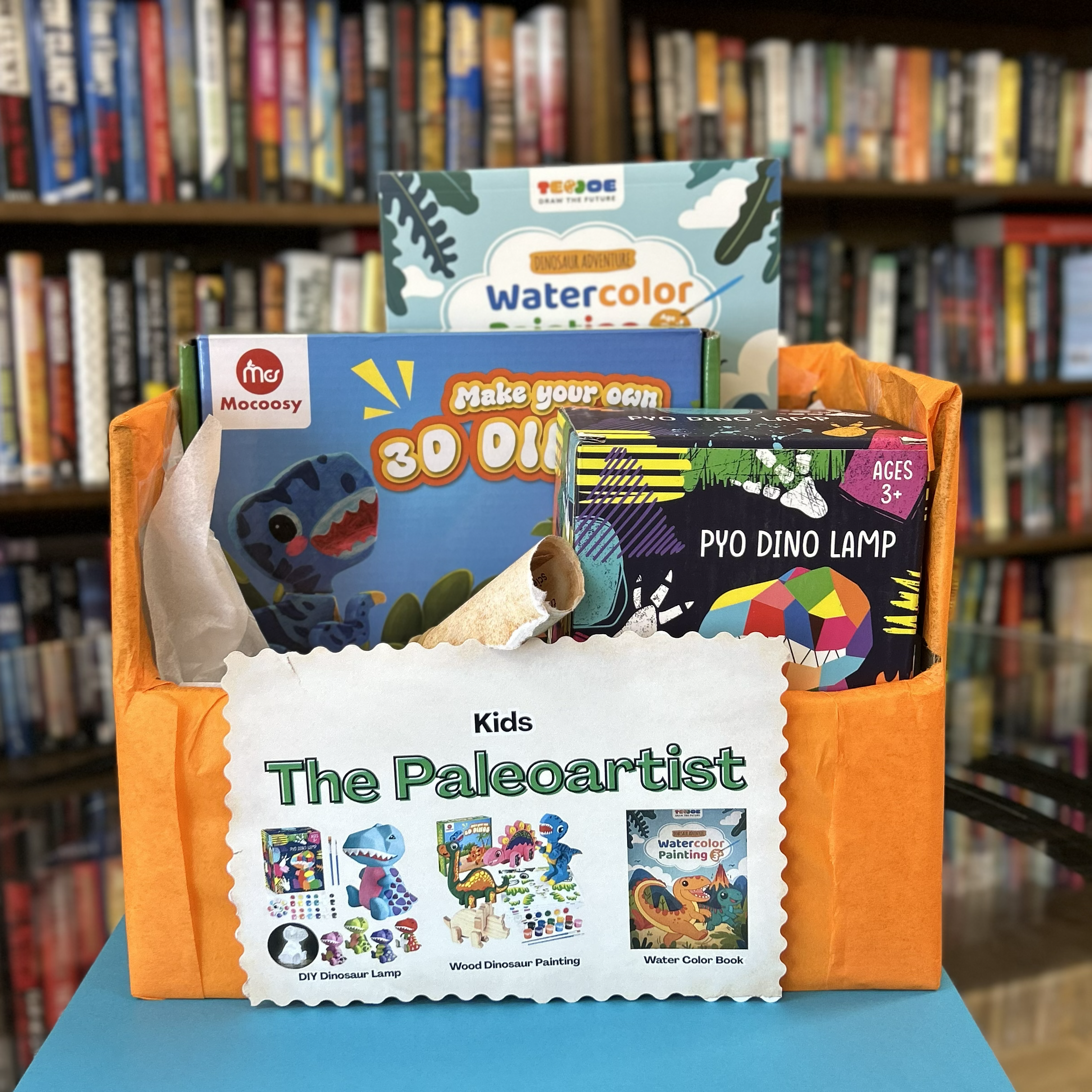 Kid Paleoartist bundle includes a wood dinosaur painting, DIY dinosaur lamp, and watercoloring pages