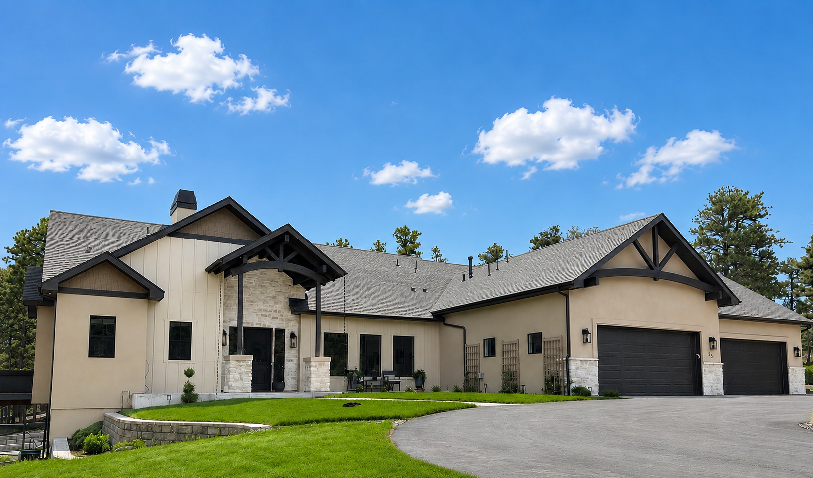 A large, modern, multi-story house with gray and white exterior, brick accents, a dark shingle roof, and a grassy front yard.