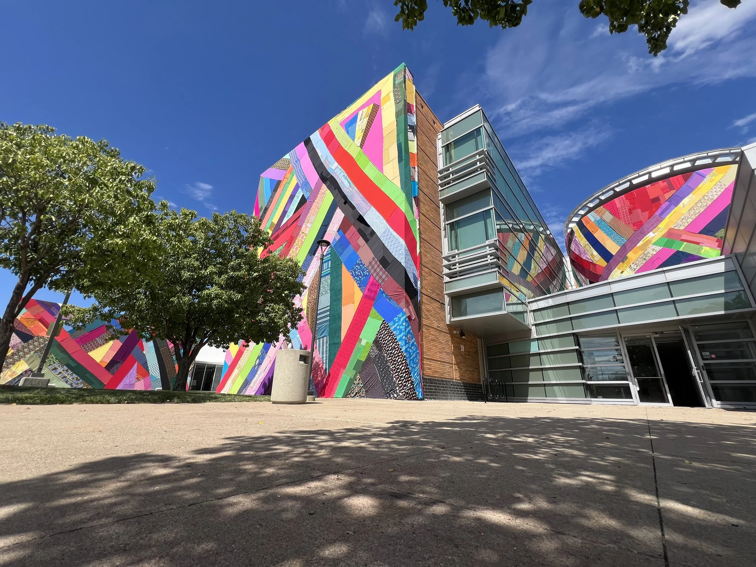 Textile installation on the outside of the art center. A tree is in front of it to show how large.