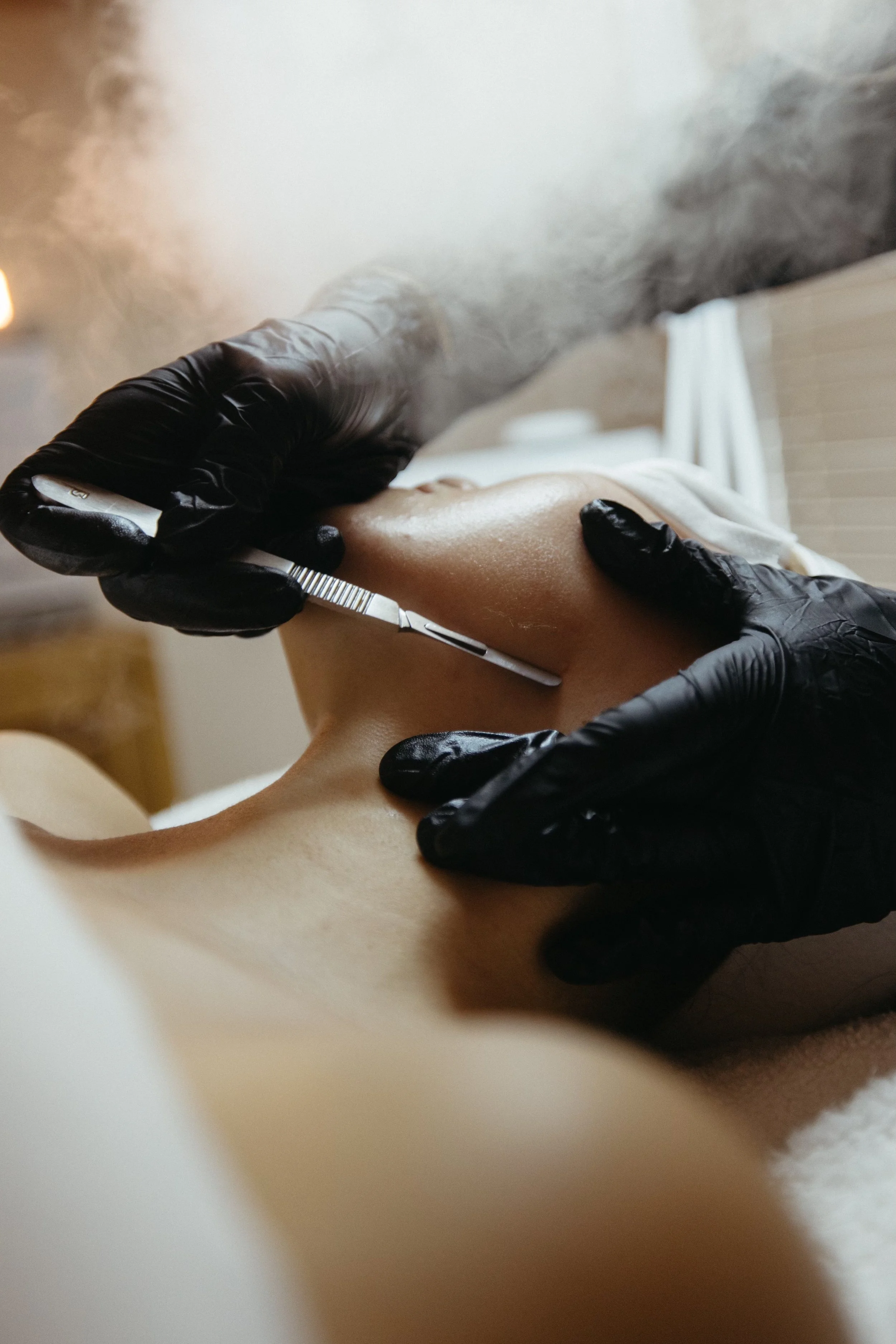 A picture of an esthetician performing a dermaplane to prep for a peel treatment