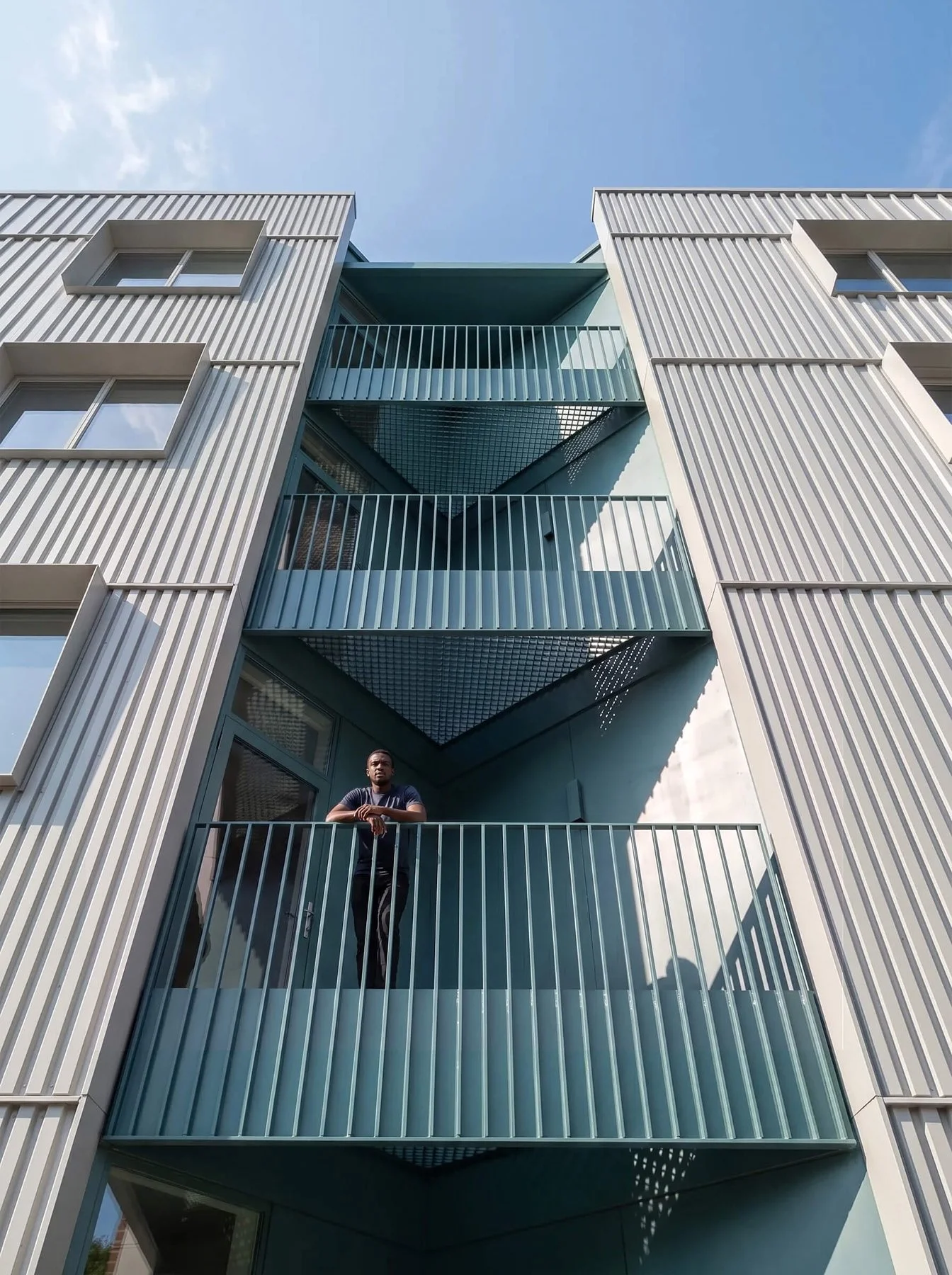 Stacked teal balconies between the metal-clad wings of Arrowhead Residences Boston
