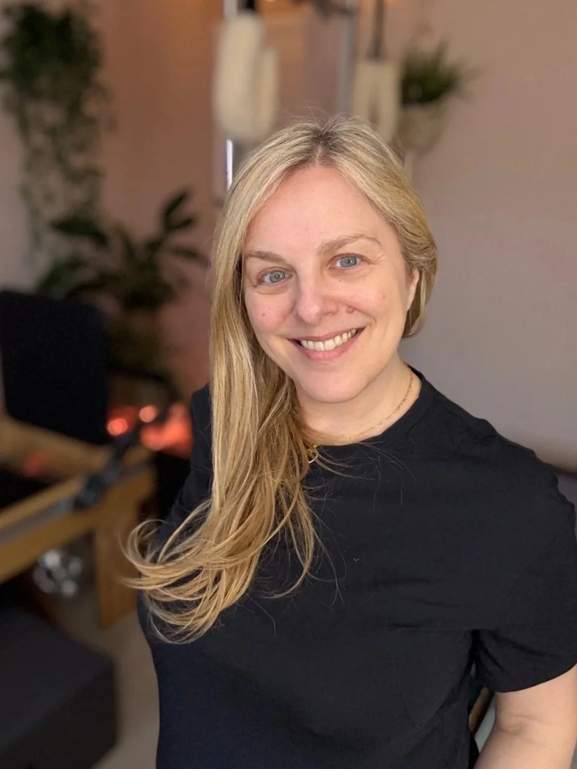 Sarah Pritchard, ISMETA Registered Master Somatic Movement Therapist and Educator (MSMT/MSME), 3rd Generation Pilates Specialist, Expert L4 Franklin Method. She smiles warmly in her virtual studio