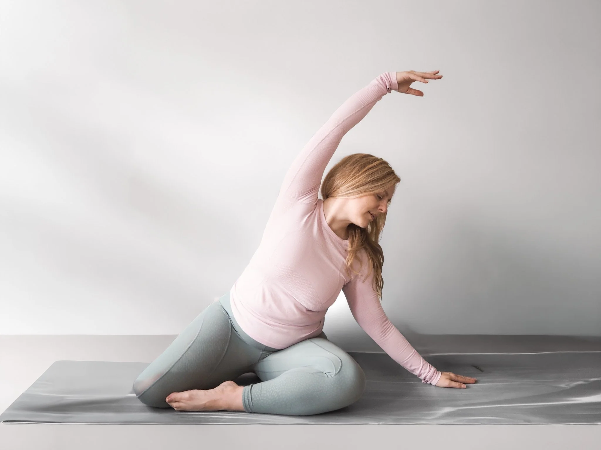 Sarah Pritchard performing a fluid Mermaid pose in a Somatic Pilates session, focusing on lateral expansion and nervous system regulation