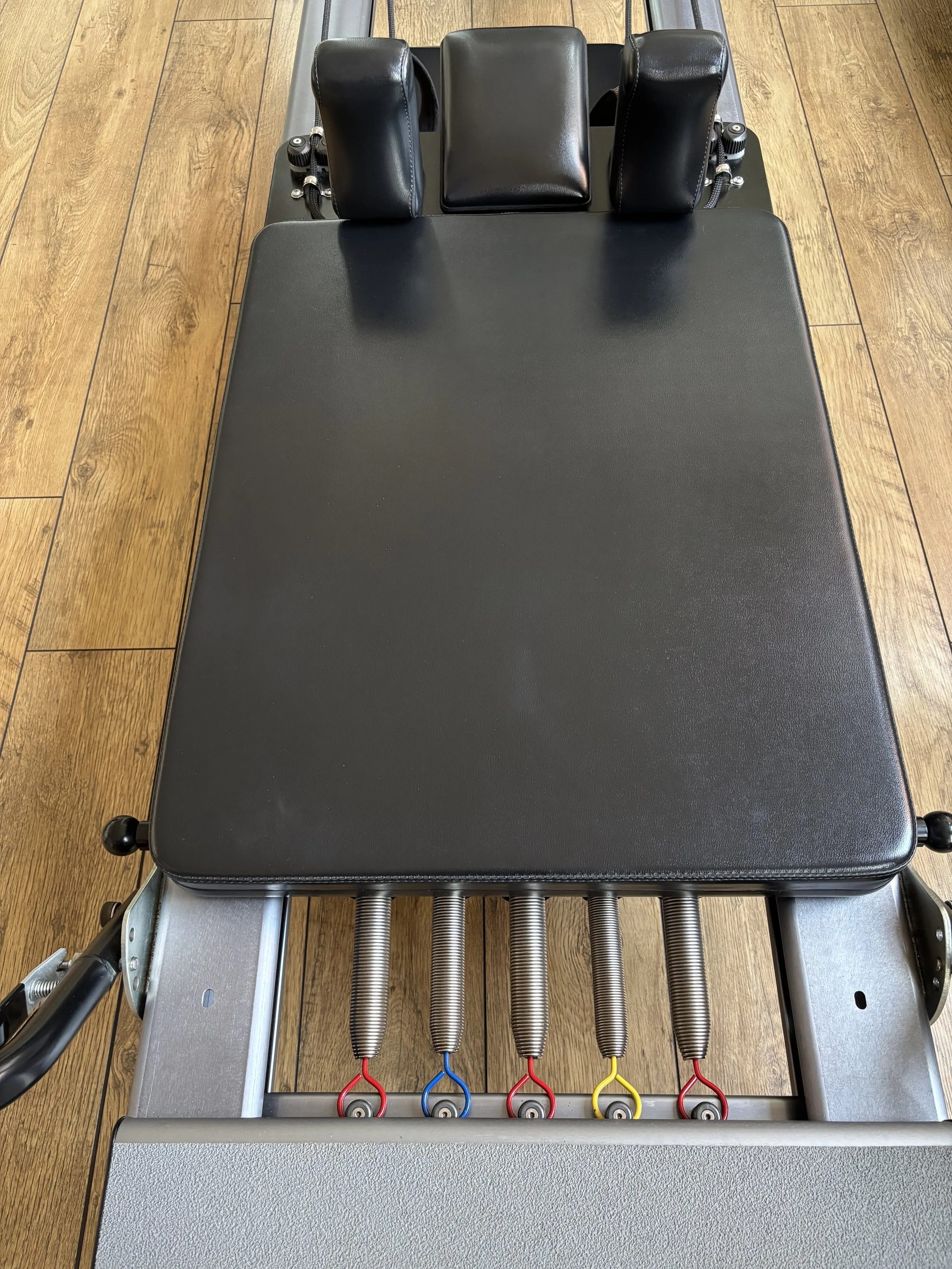 Close-up of a studio Pilates Reformer at Cool Pilates, Birmingham Jewellery Quarter. Used by Level 4 Expert Sarah Pritchard for remedial Pilates, somatic movement, and expert-led Buff Bones and pilates for osteoporosis bone health classes