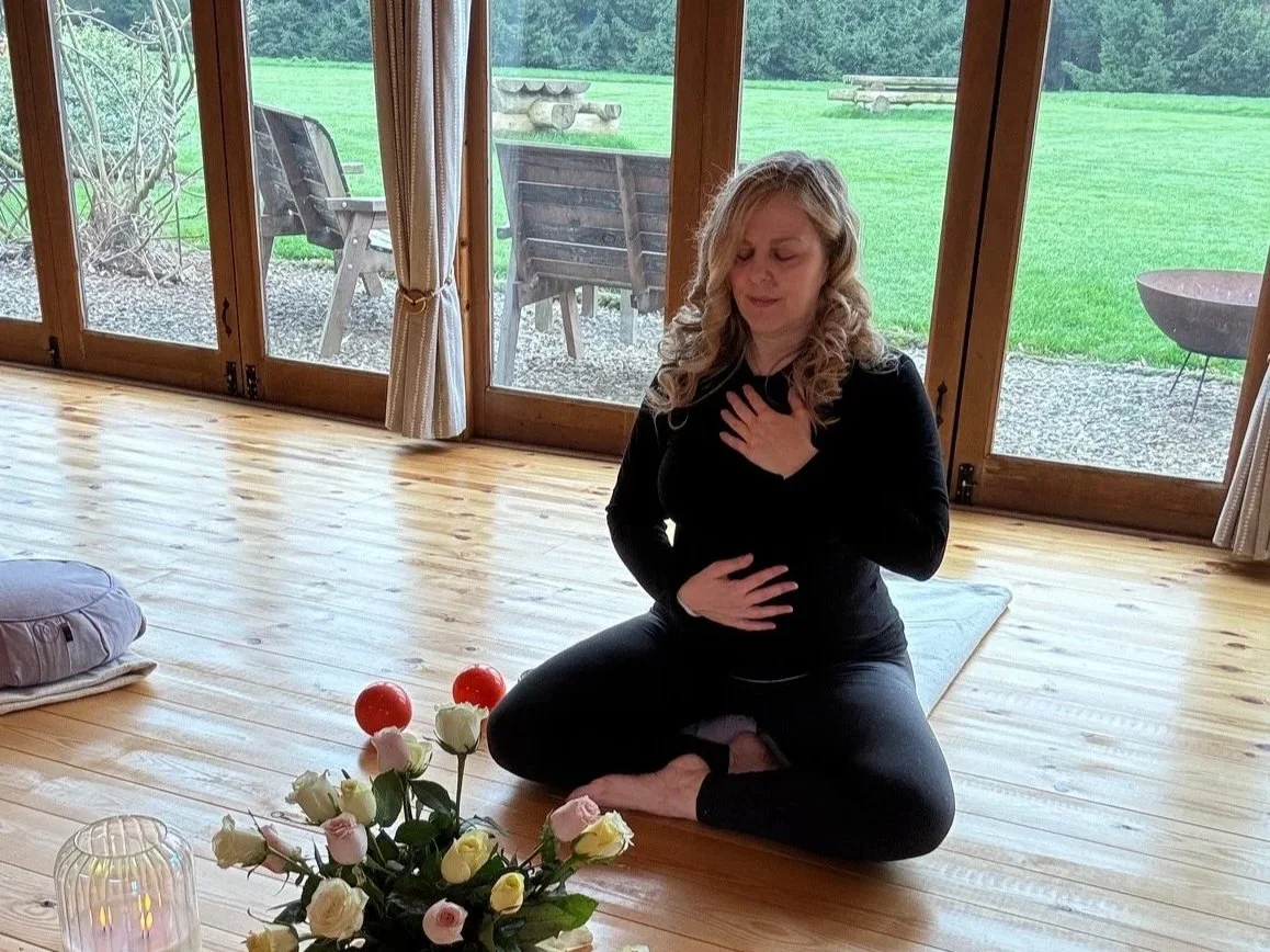 Sarah Pritchard, ISMETA Registered Master Somatic Movement Therapist and Educator (MSMT/MSME), placing a hand over her heart in a gentle somatic connection practice during a movement retreat at Newton Meadows near Shrewsbury.