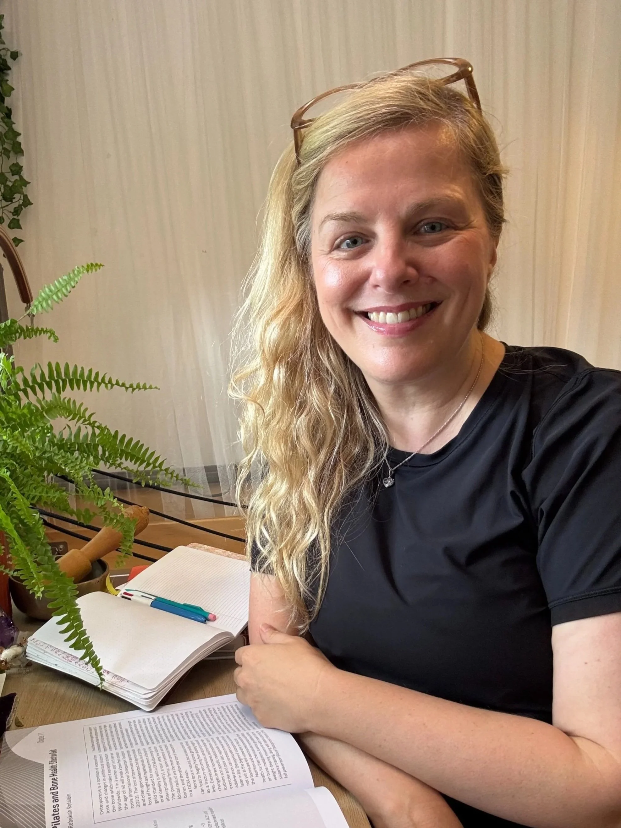 A warm portrait of Sarah Pritchard, ISMETA Registered Master Somatic Movement Therapist and Educator (MSMT/MSME), smiling and welcoming visitors from her peaceful virtual studio desk.