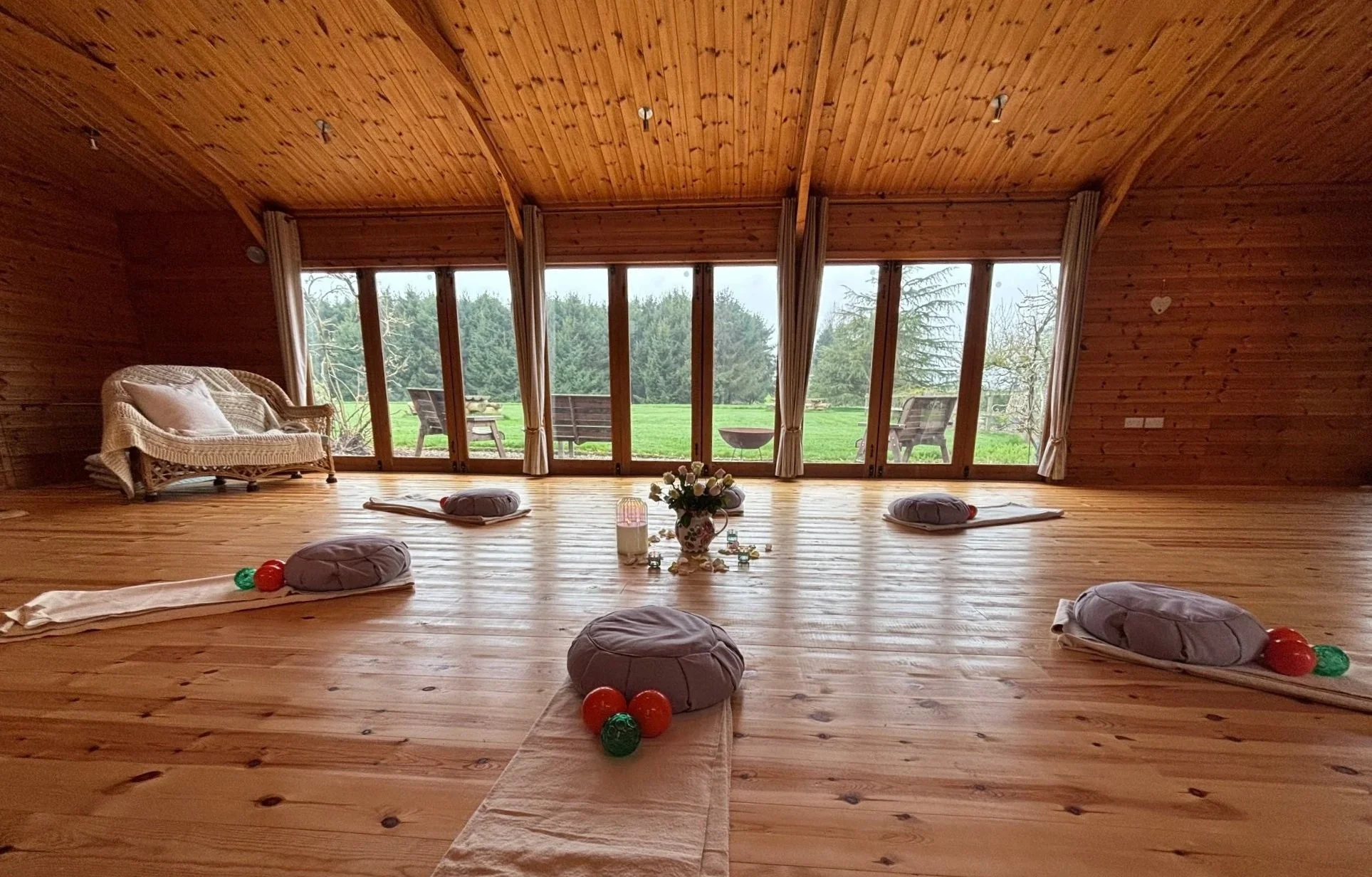 The light-filled somatic movement studio, Newton Meadows, Shrewsbury. Floor cushions, Franklin Method® balls arranged, with large windows overlooking the Shropshire countryside and pine trees, a restorative sanctuary for nervous system regulation