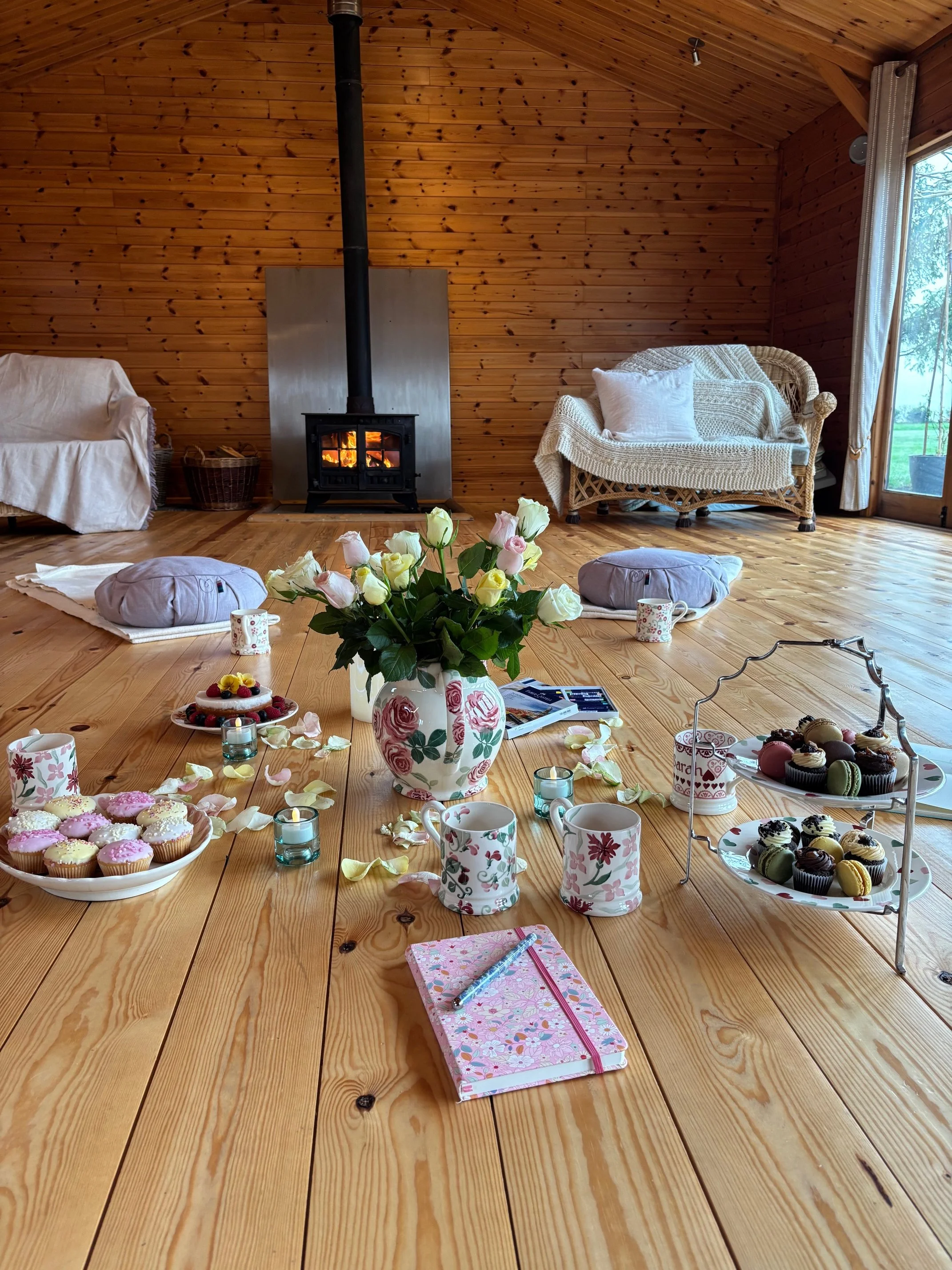 A restorative retreat setting at Newton Meadows, Shrewsbury, featuring a log burner, floor cushions, and nourishing treats. A safe, trauma-informed space for midlife women's somatic therapy and nervous system regulation in Shropshire