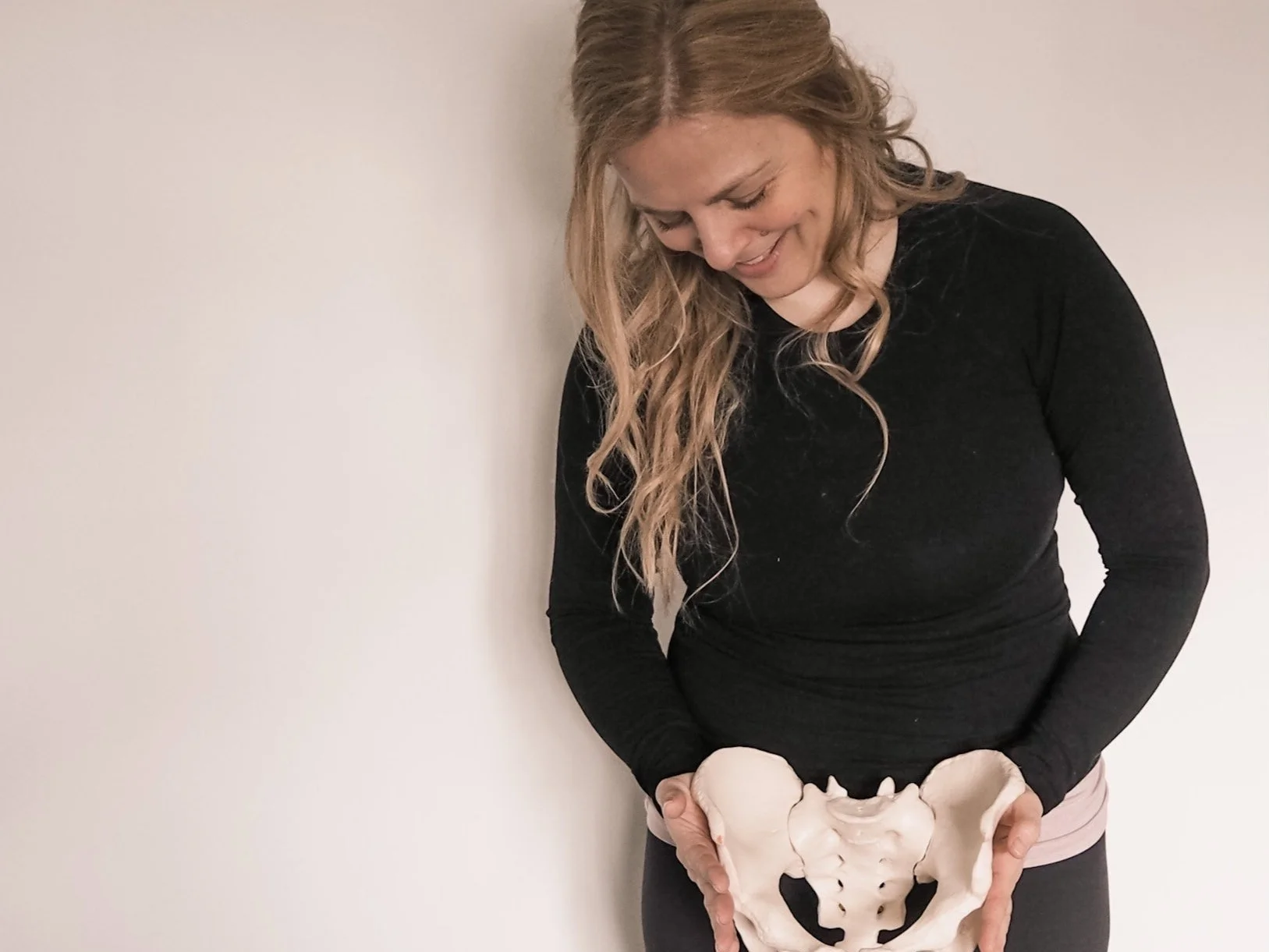 Sarah Pritchard, Level 4 Franklin Method Educator, demonstrating pelvic biomechanics using a physical pelvis model during a somatic movement workshop.