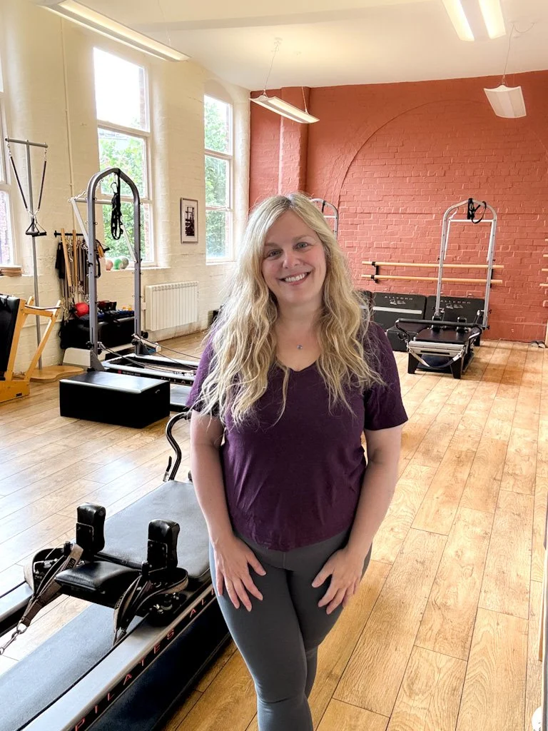 Sarah Pritchard, a comprehensively trained studio Pilates instructor and Somatic Movement Therapist (MSMT), in a Birmingham studio with reformer equipment.
