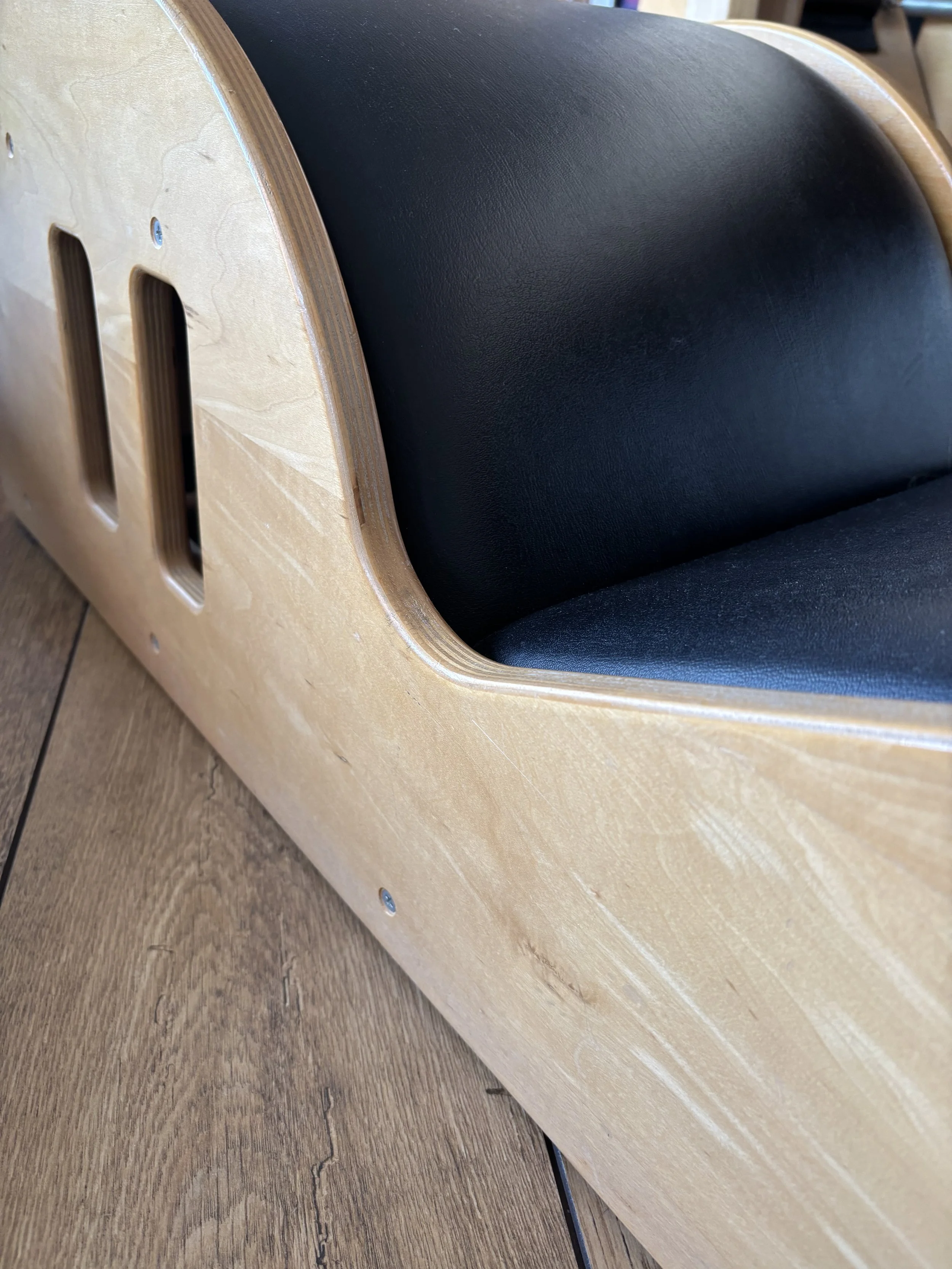 Close-up of a wooden Pilates Spine Corrector barrel used by Sarah Pritchard for remedial Pilates and somatic movement therapy in Shrewsbury and Birmingham studios.