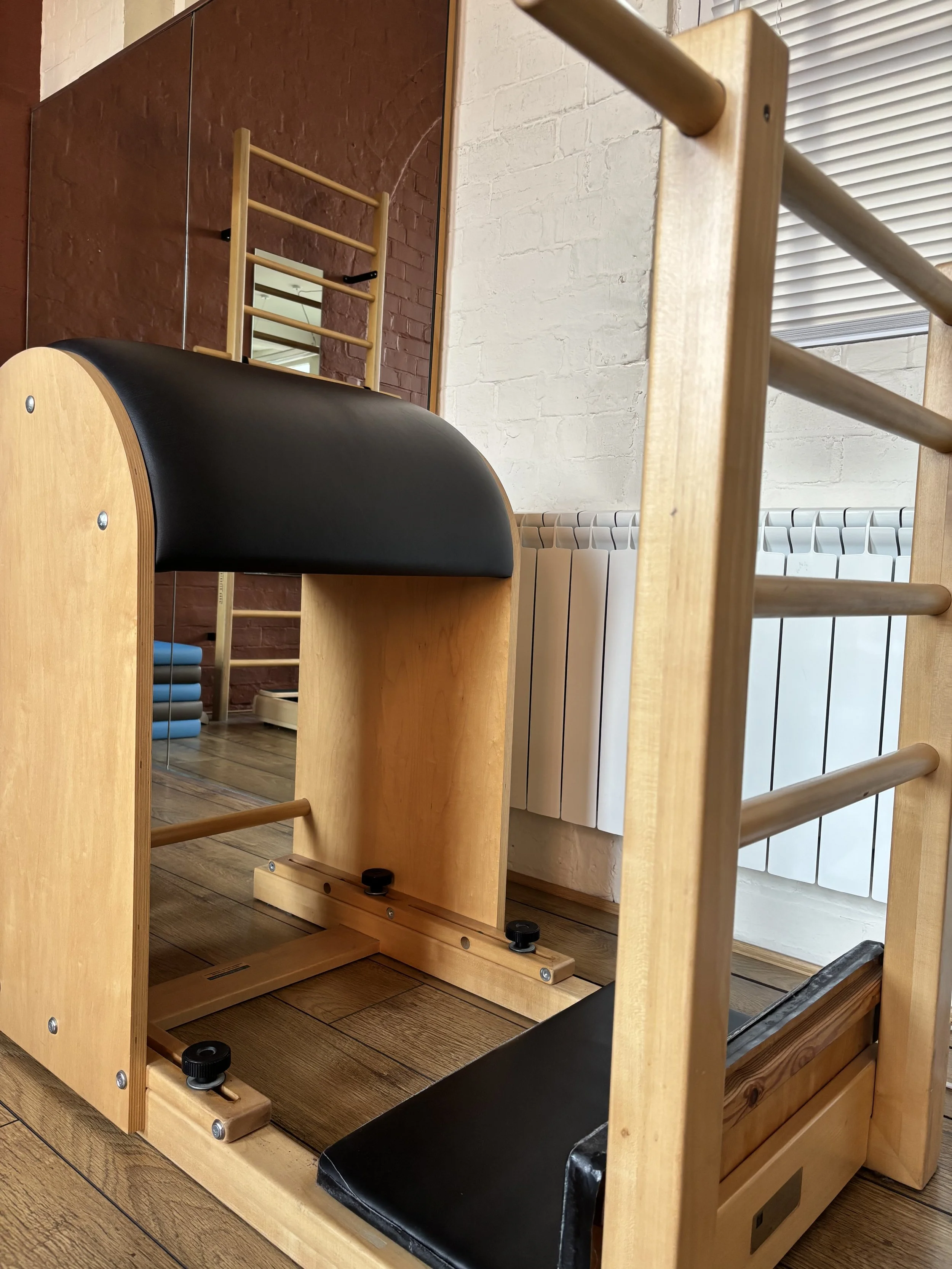Professional Pilates Ladder Barrel in a bright Birmingham Jewellery Quarter studio with exposed brickwork, used for bespoke spinal mobility and core strength sessions.