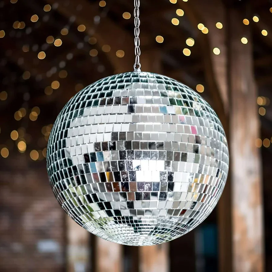 A shiny disco ball hanging from the ceiling, surrounded by blurred warm lights in the background.