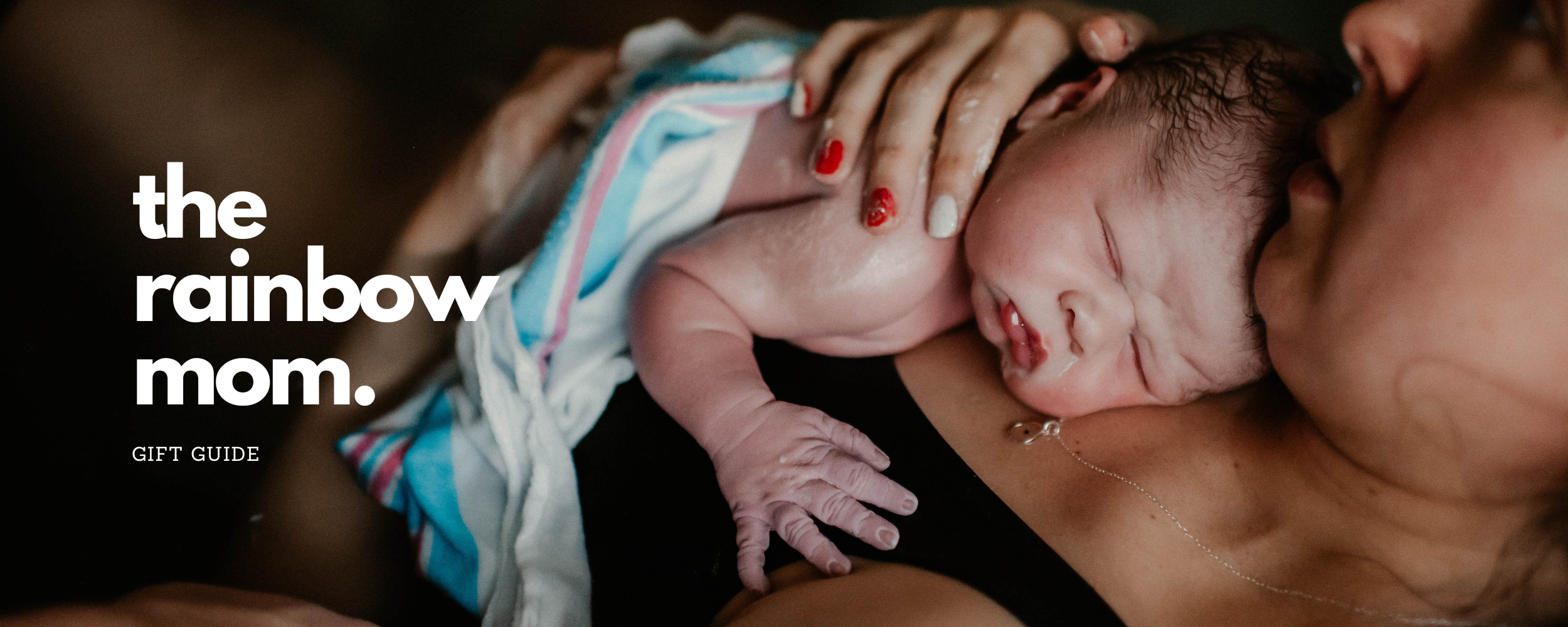 mom holding just born baby, baby's hands are wrinkly and moms red painted fingernails are covered in vernix