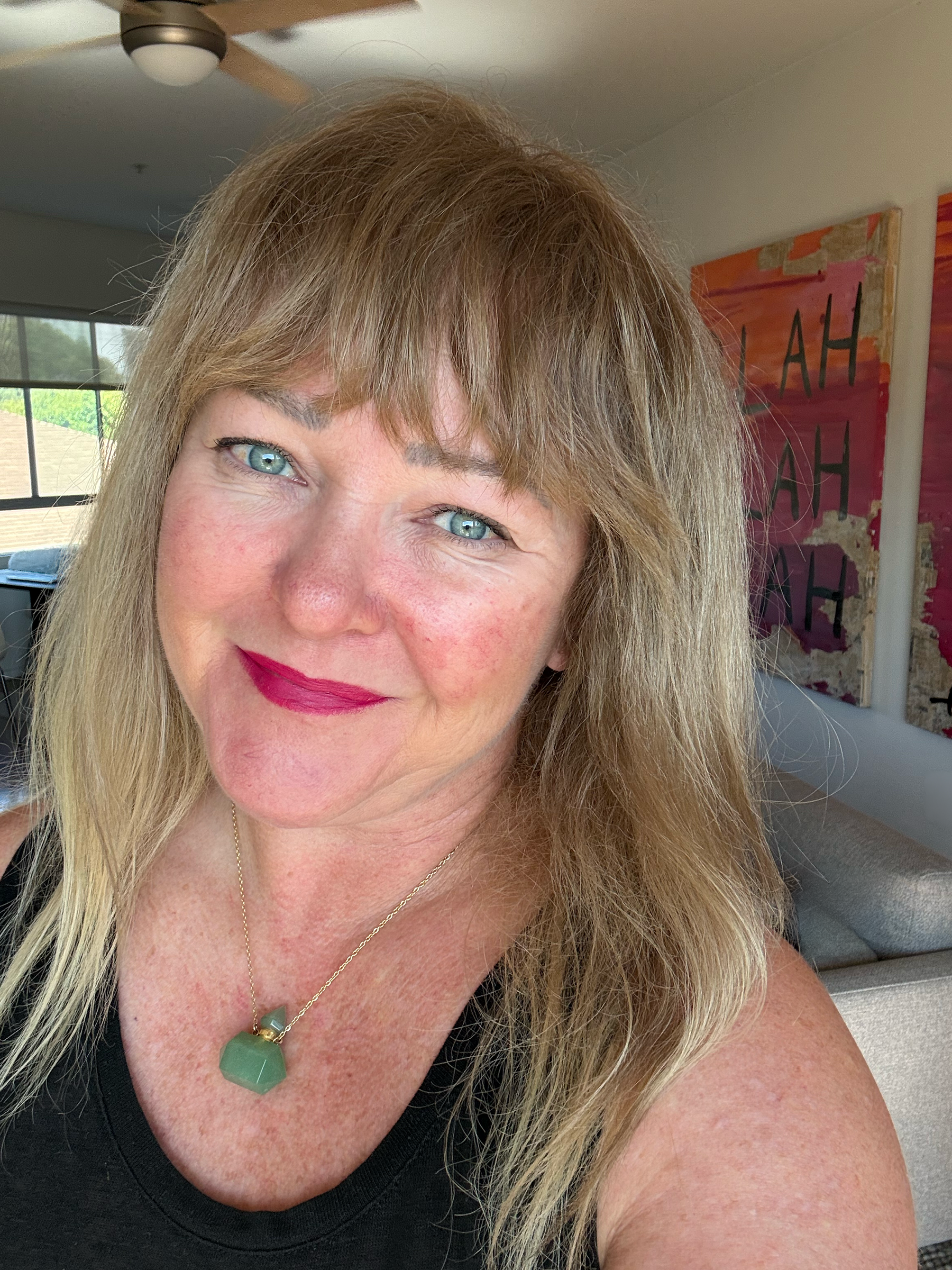 Julia Gomelsky looking at the camera in her living room with art in the background