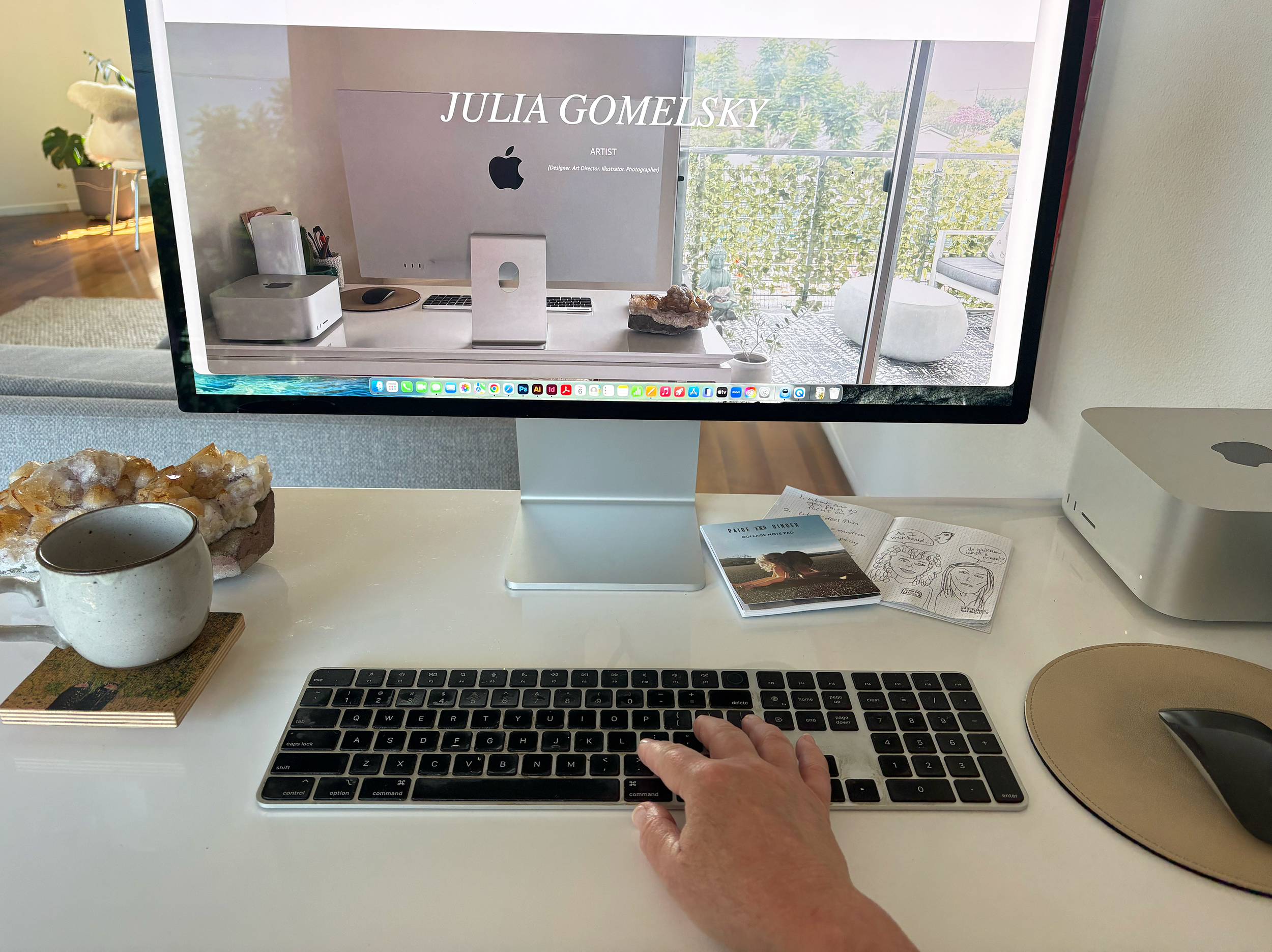 Julia Gomelsky, hand on keyboard at desk with Julia Gomelsky website on the desktop screen