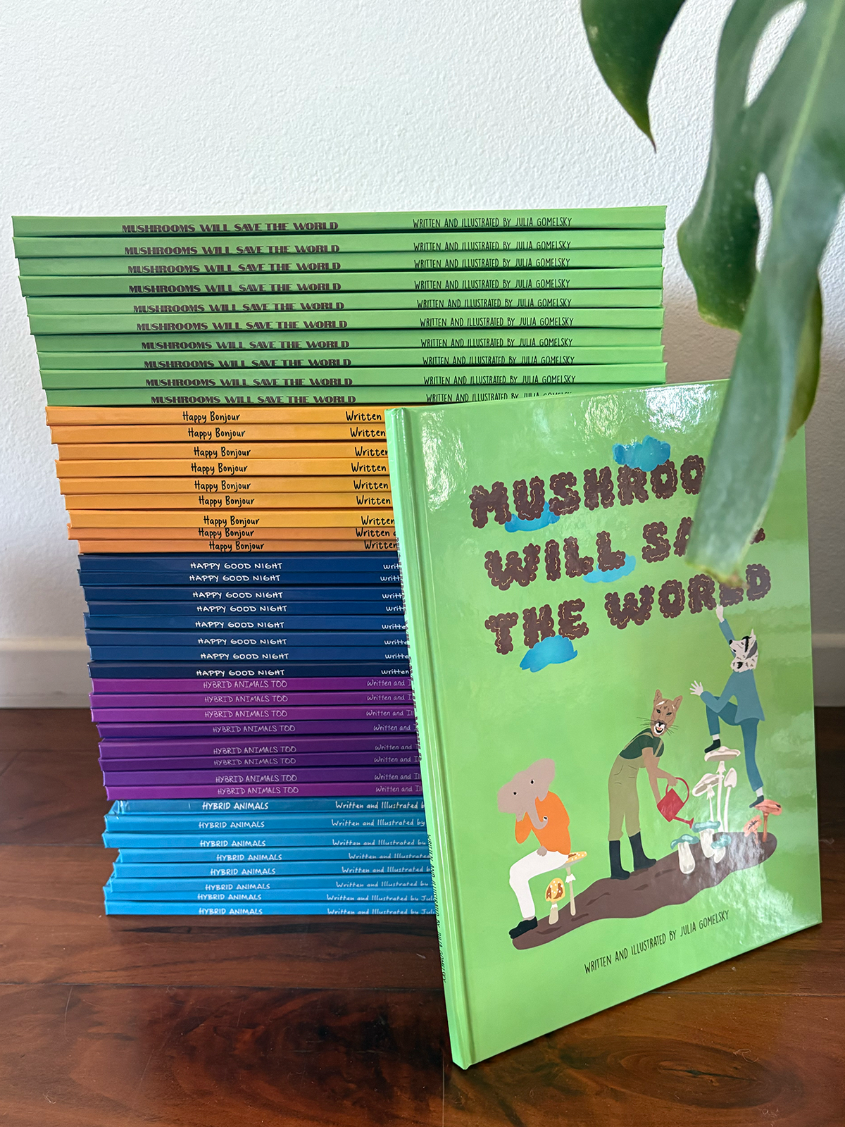 Stack of five different children's books on the floor with one facing up titled "Mushrooms Will Save the World"