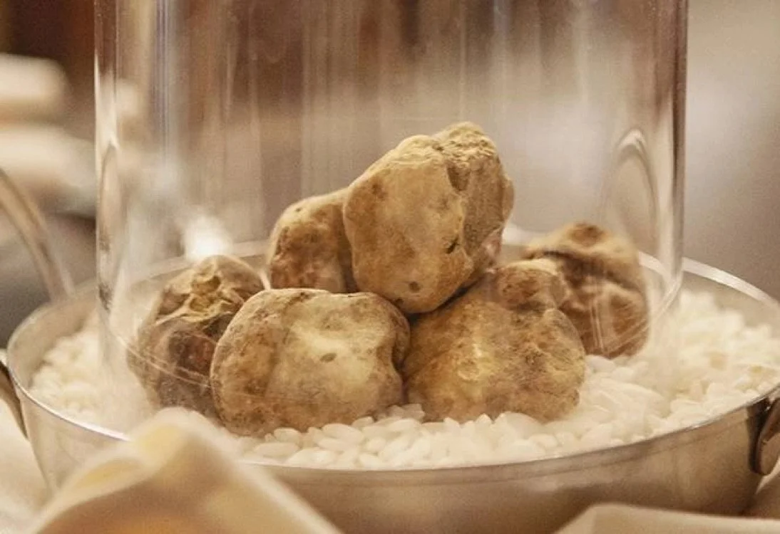 Close-up of a glass container holding russet potatoes resting on white rice.