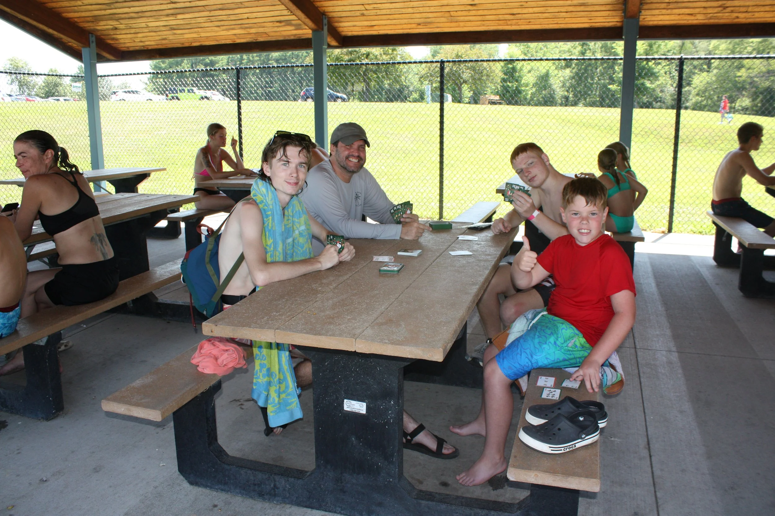 Tim playing a card game with campers and volunteers