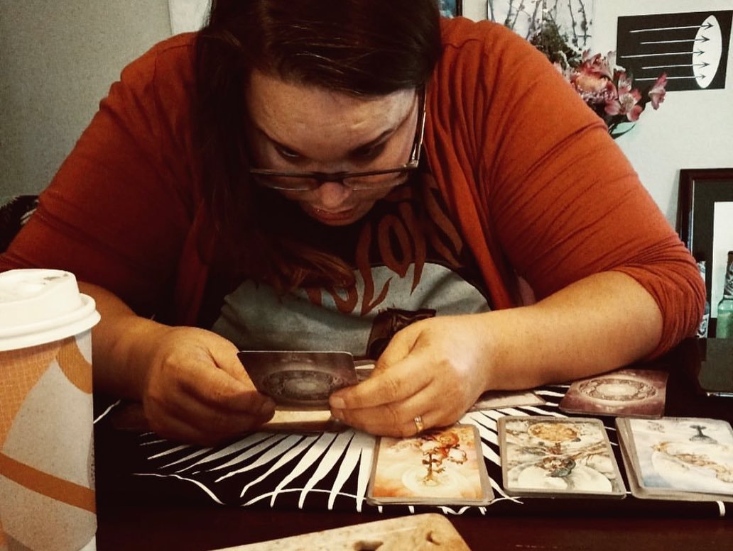 A photo of Natalie deeply analyzing a tarot card.