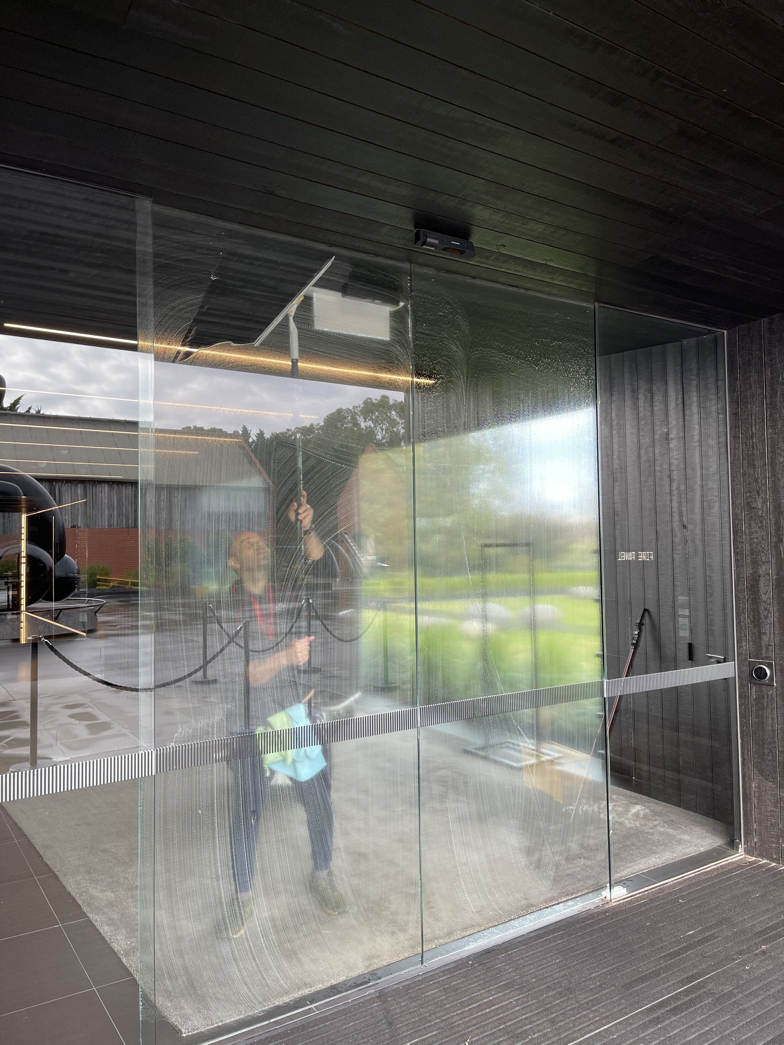 Christian doesn't just clean windows! Here he is cleaning these glass doors in Merricks.