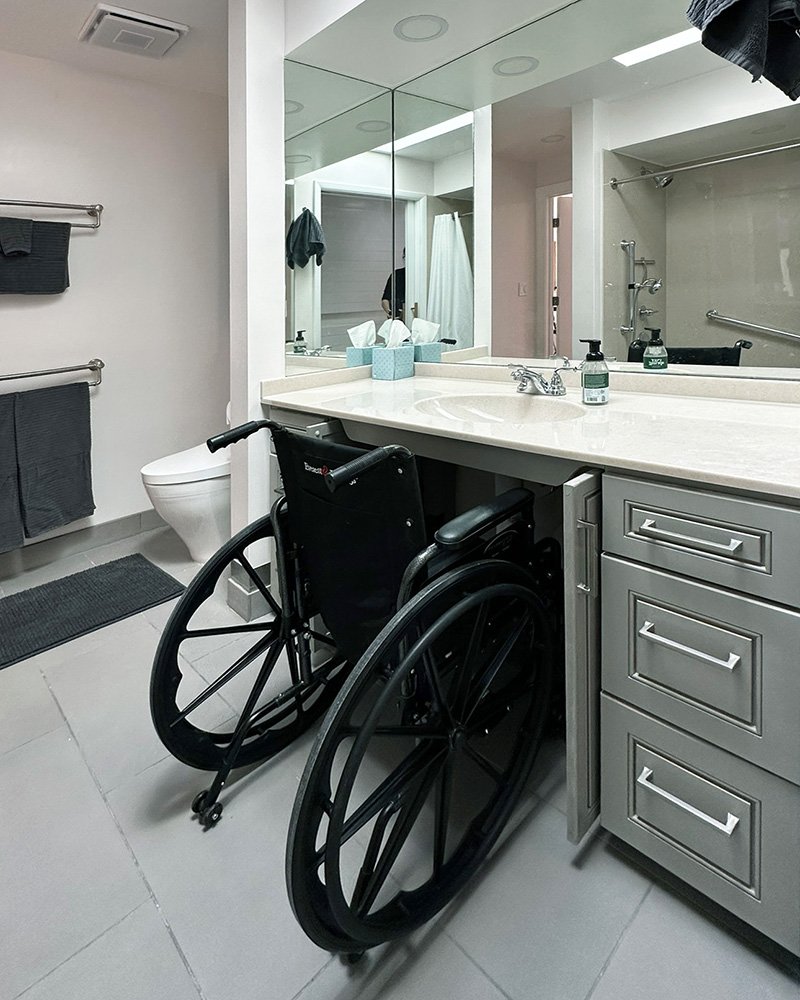 In the main bathroom, the cabinet below the sink opens to allow a wheel chair to roll beneath the vanity.