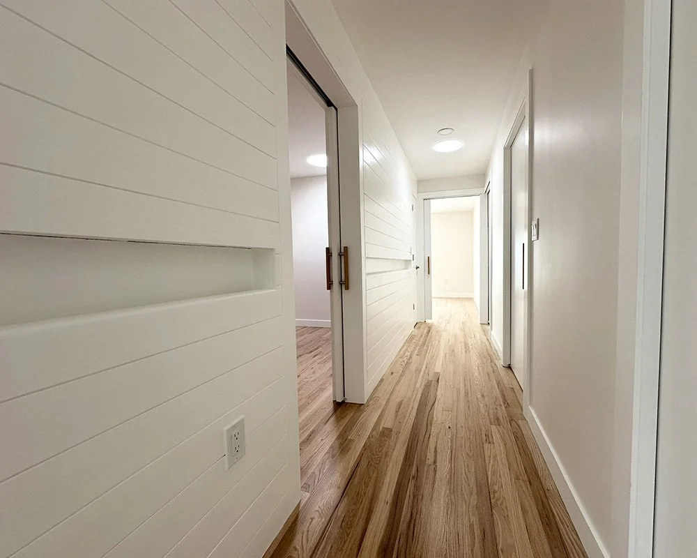 The hallway connecting the bedrooms and bathrooms. We know that not everyone gets a fancy set of wheels, but sometimes you need a little extra support. So we recessed a handrail in the ship lap.