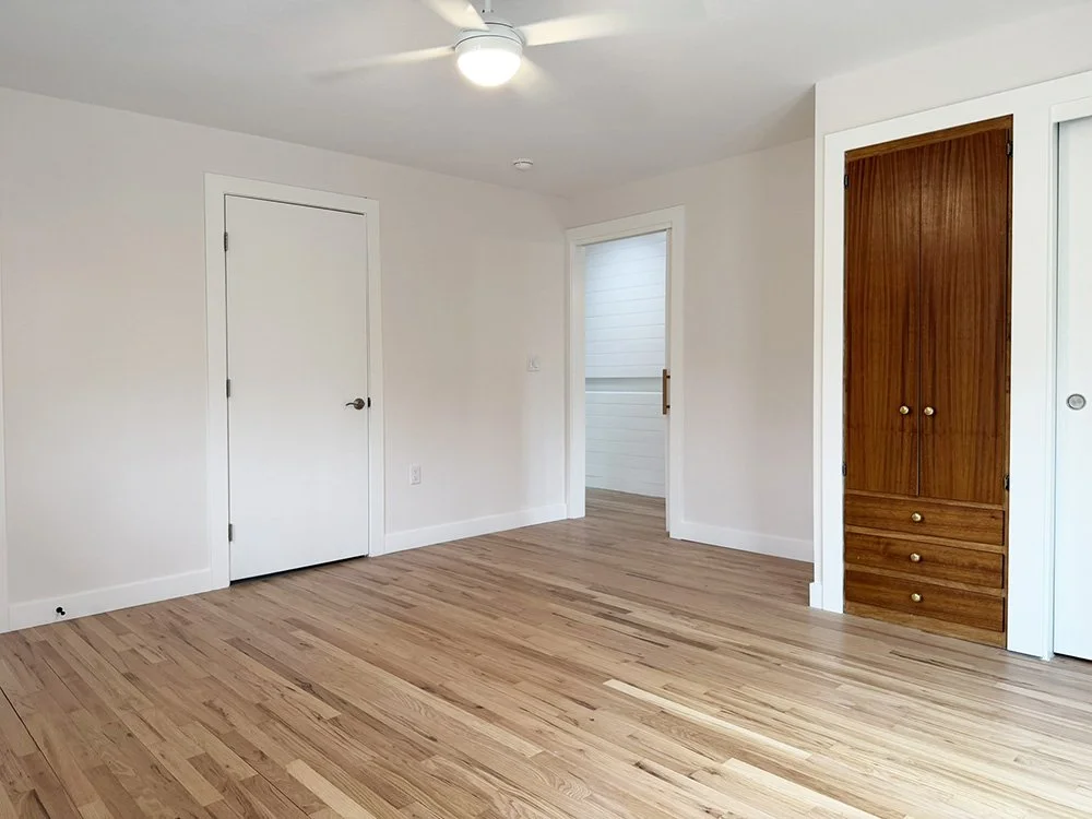 View of the Primary Suite bedroom toward the hall. There is some built-in storage in addition to closet space. 