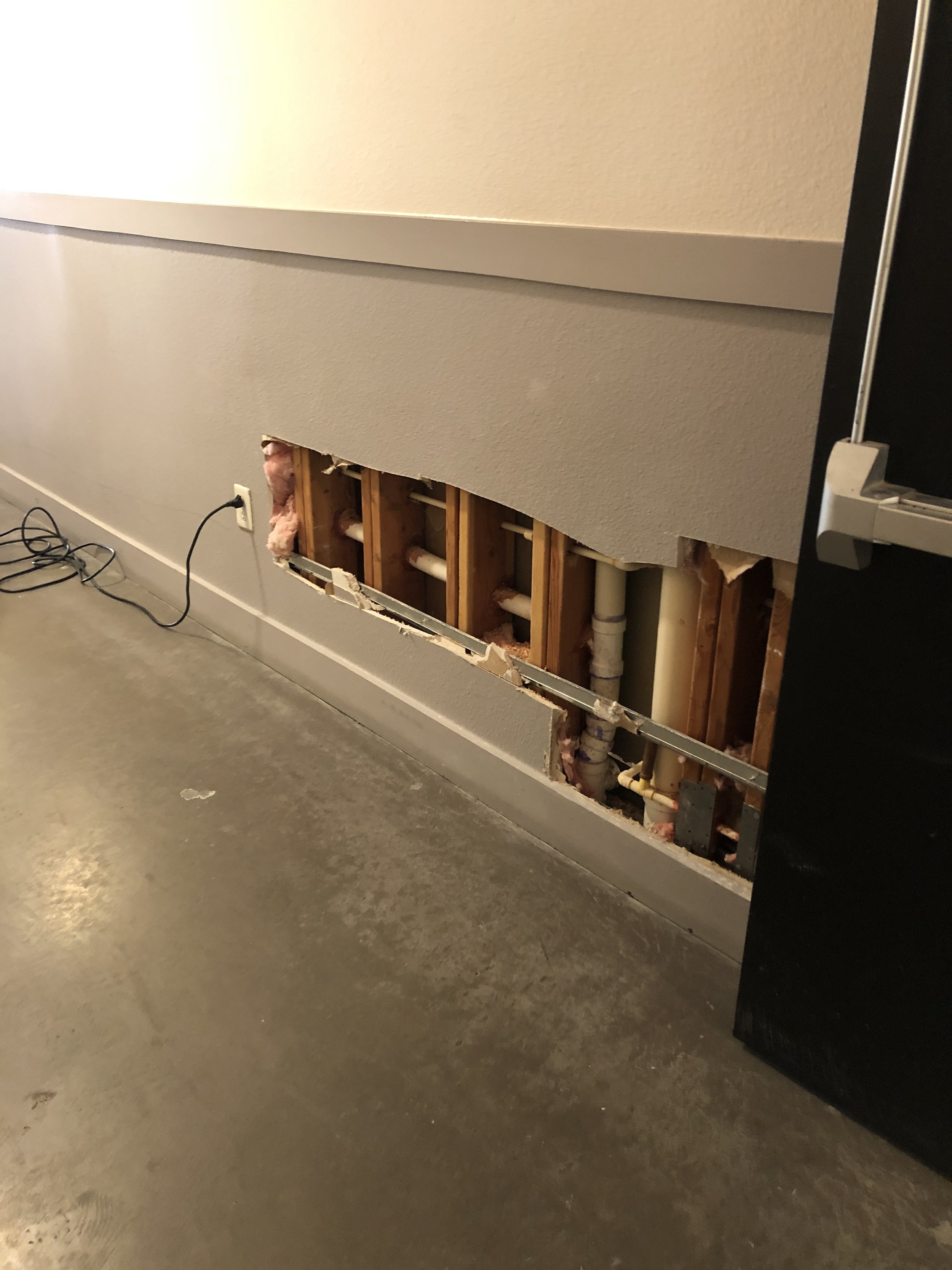 Chasing the fire suppression system in the hallway of the structure to find any leaks.