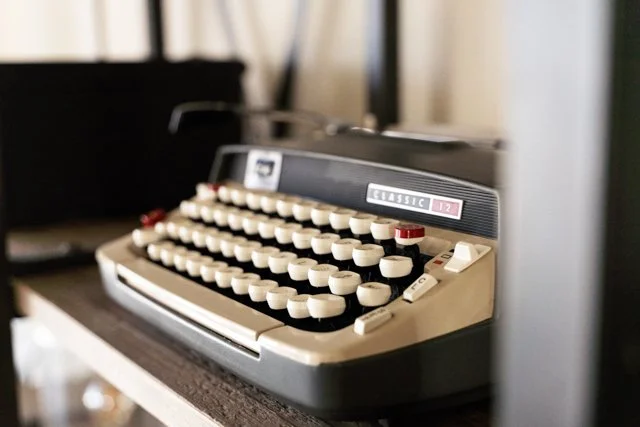 Close-up of vintage typewriter on wooden surface with background blurred.