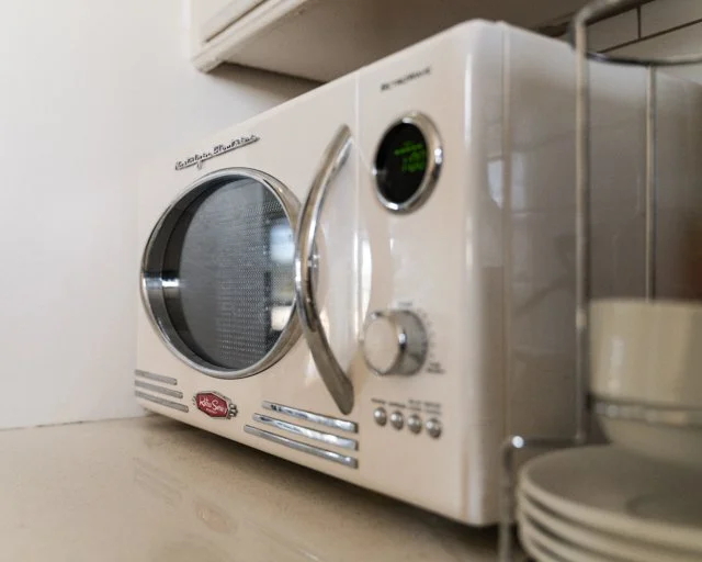 White countertop microwave oven with digital display and control buttons.