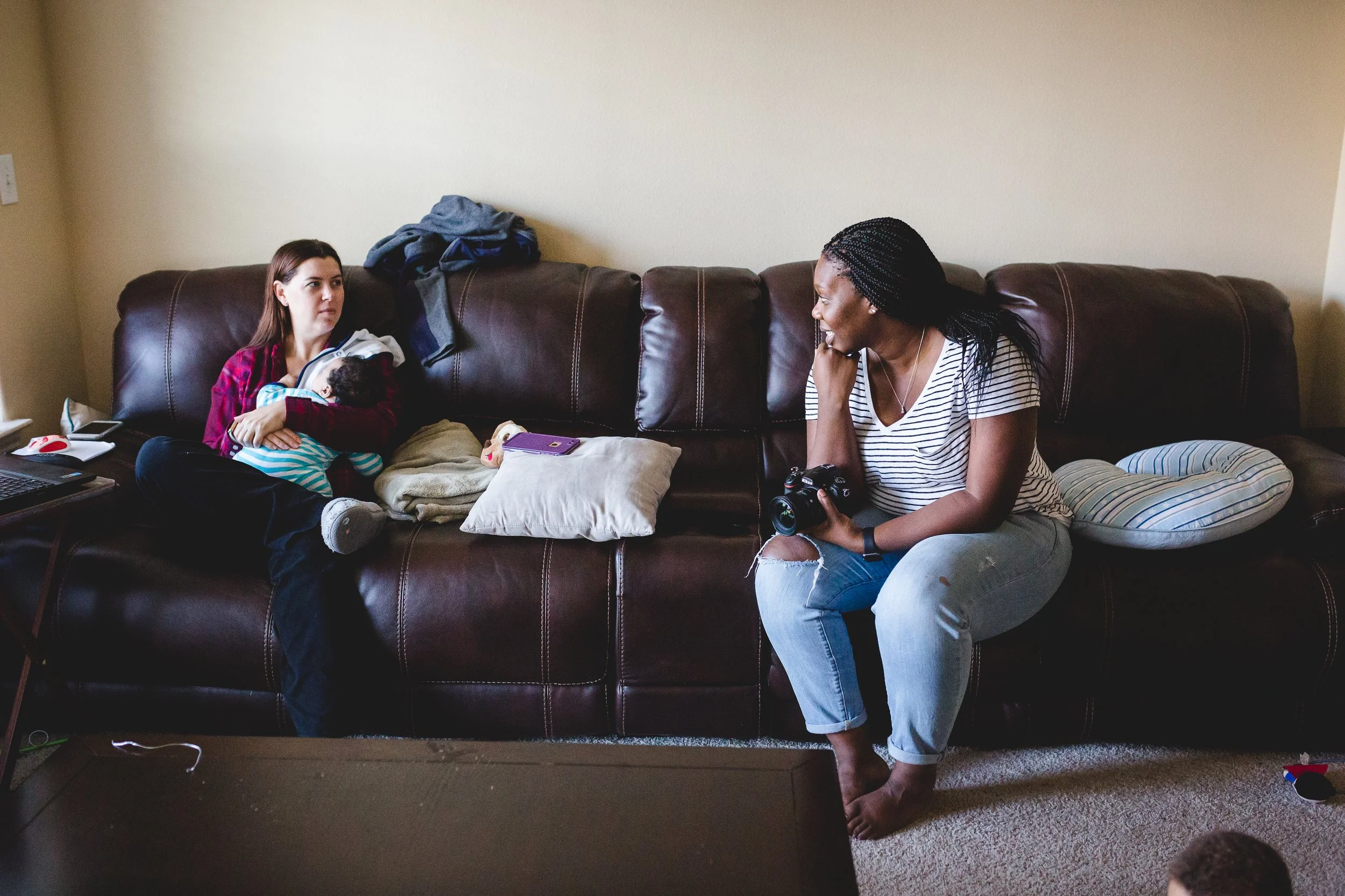 moms talking while holding baby during a photography session