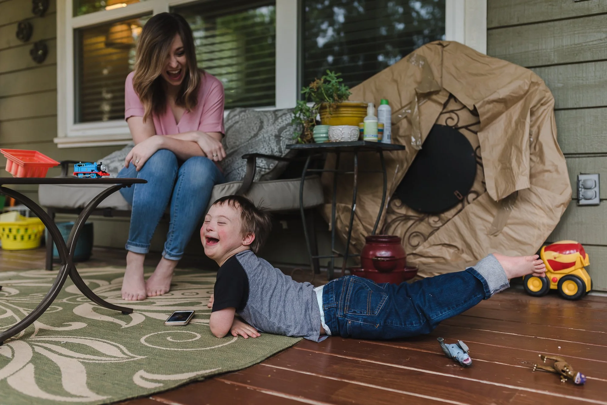 boy and mom laughing on back patio