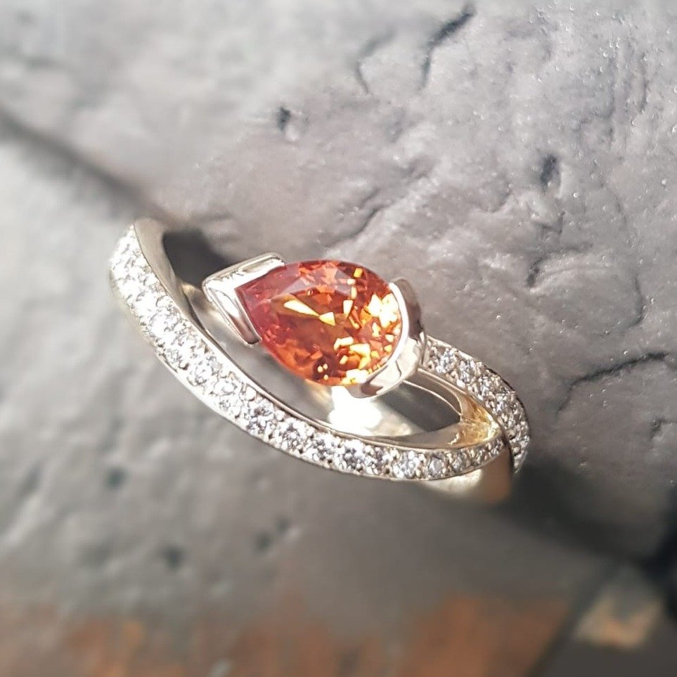 We love it when we get to play with our designs and try out something we've never done before.  This customer commission gave us just that opportunity - setting a vibrant Orange Sapphire to create a unique version of our beautifully balanced Satellit