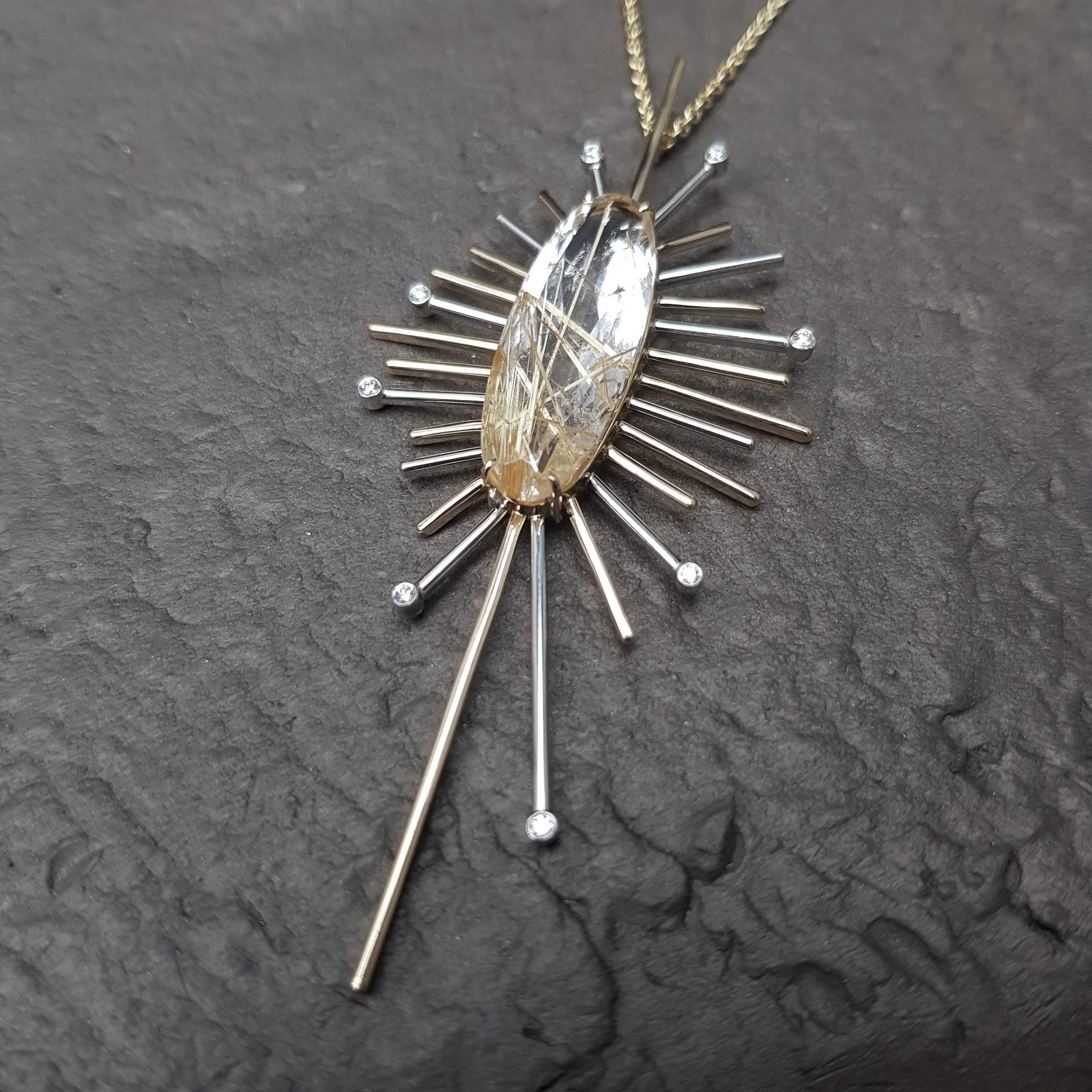 This one's for you if you want to make a statement! Aztek - a one of piece centred around an elongated oval Rutile Quartz. We've used both 9ct yellow and platinum to echo the colours of the stone and peppered diamonds around the edges.

Aztek unique 