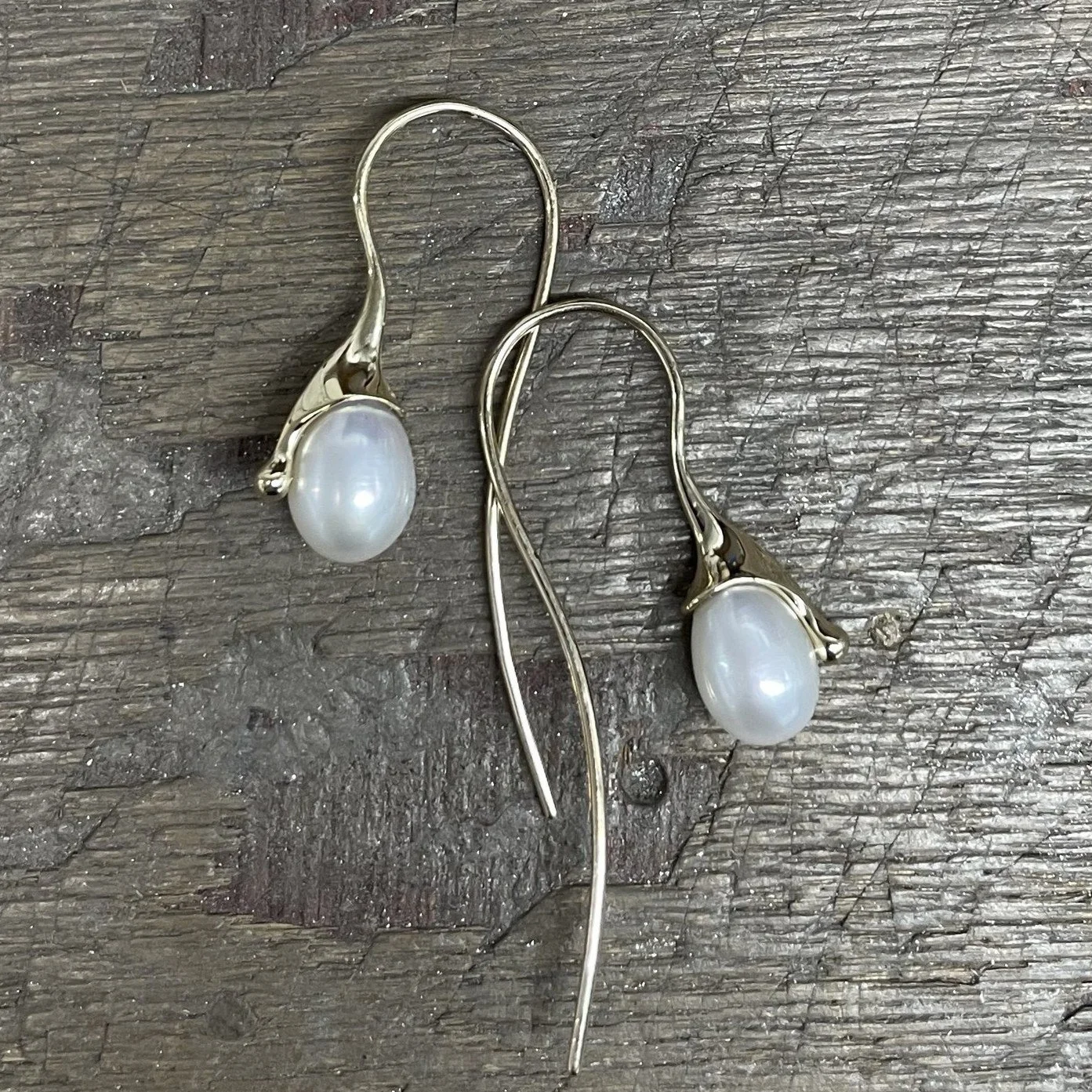 New this year as a special addition to our molten ranges, we have hand made these super elegant drop earrings featuring a pear drop shaped pearl. Shown here in 9ct yellow gold, we also have a silver pair available. 

Molten Drip Pearl Drop Earrings 9