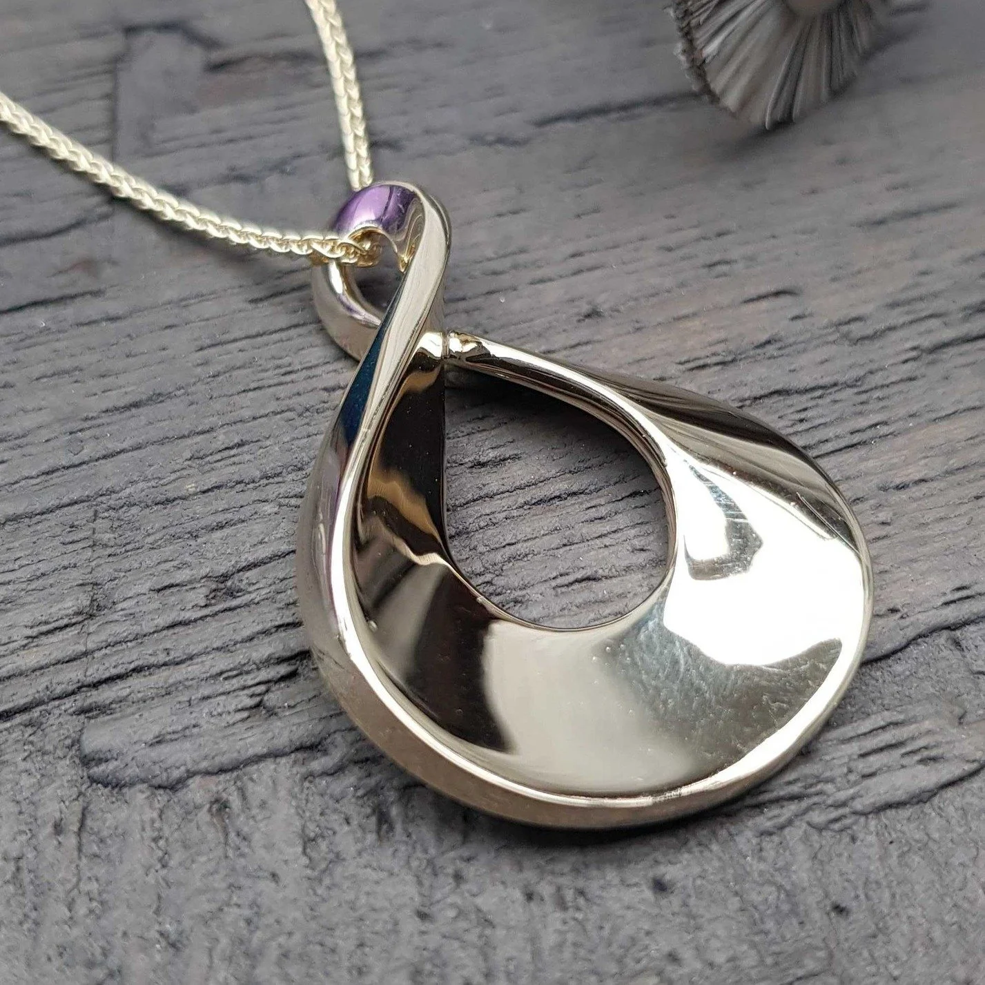 Our Large Limitless pendant - an eternal loop of highly polished, sweeping, solid gold or silver - this sculptural piece catches reflections in the most wonderful way and something about the weight of the solid metal makes it a really reassuring pend