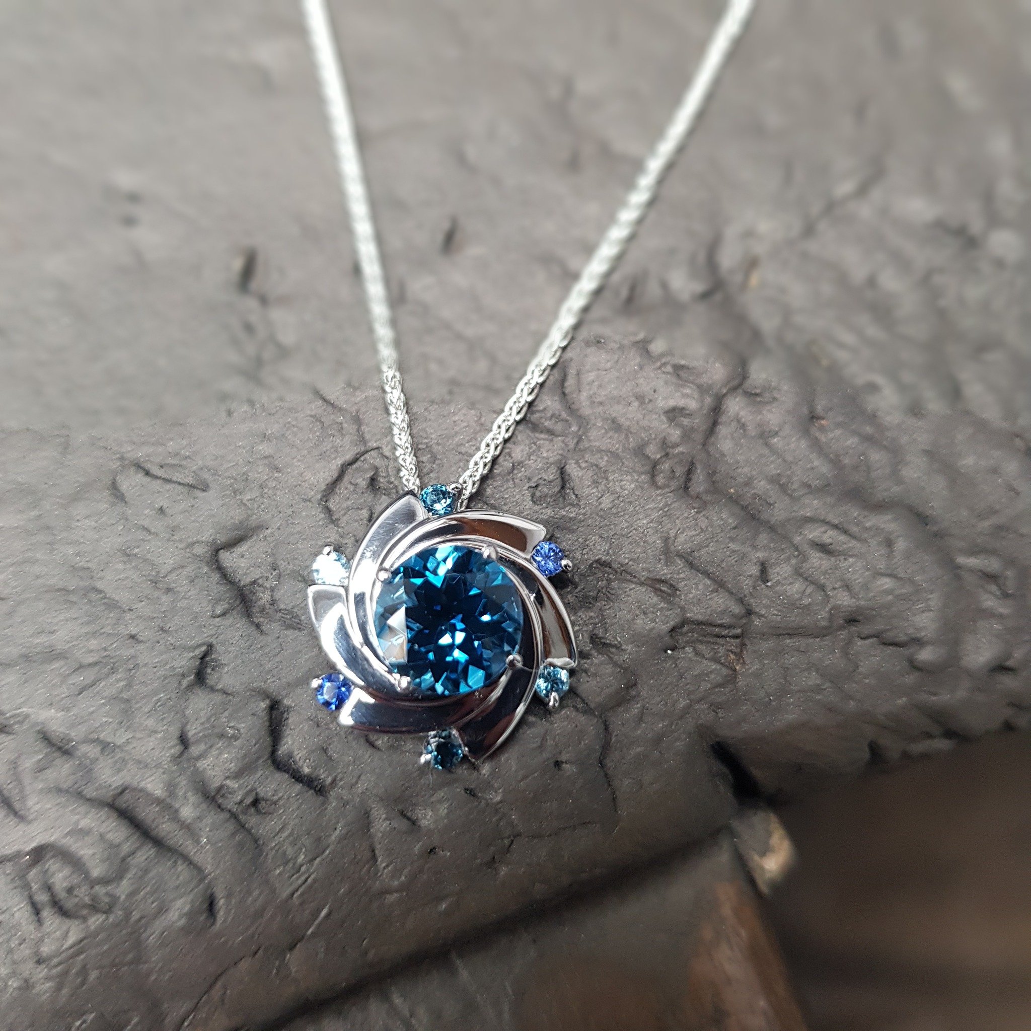 We've been having a bit of fun playing with the colours in our Aurora pendants this week. We've experimented with setting one of them with coloured semi precious stones rather than diamonds around the edges.  What do you think?  I love it - seems lik