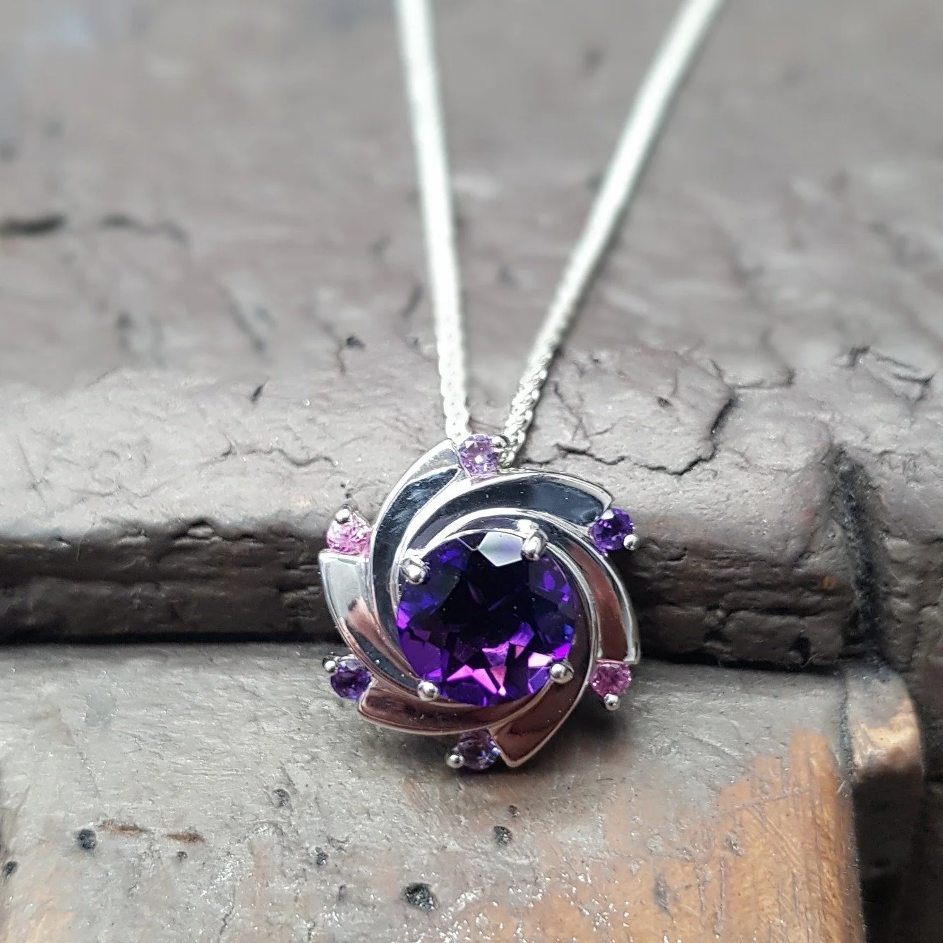 We're back with another version of the Aurora pendant - this time with pinks and purples. The central Amethyst is set off by smaller amethysts along with pink and light purple sapphires.  Such a lovely versatile design - any other colours / stones we