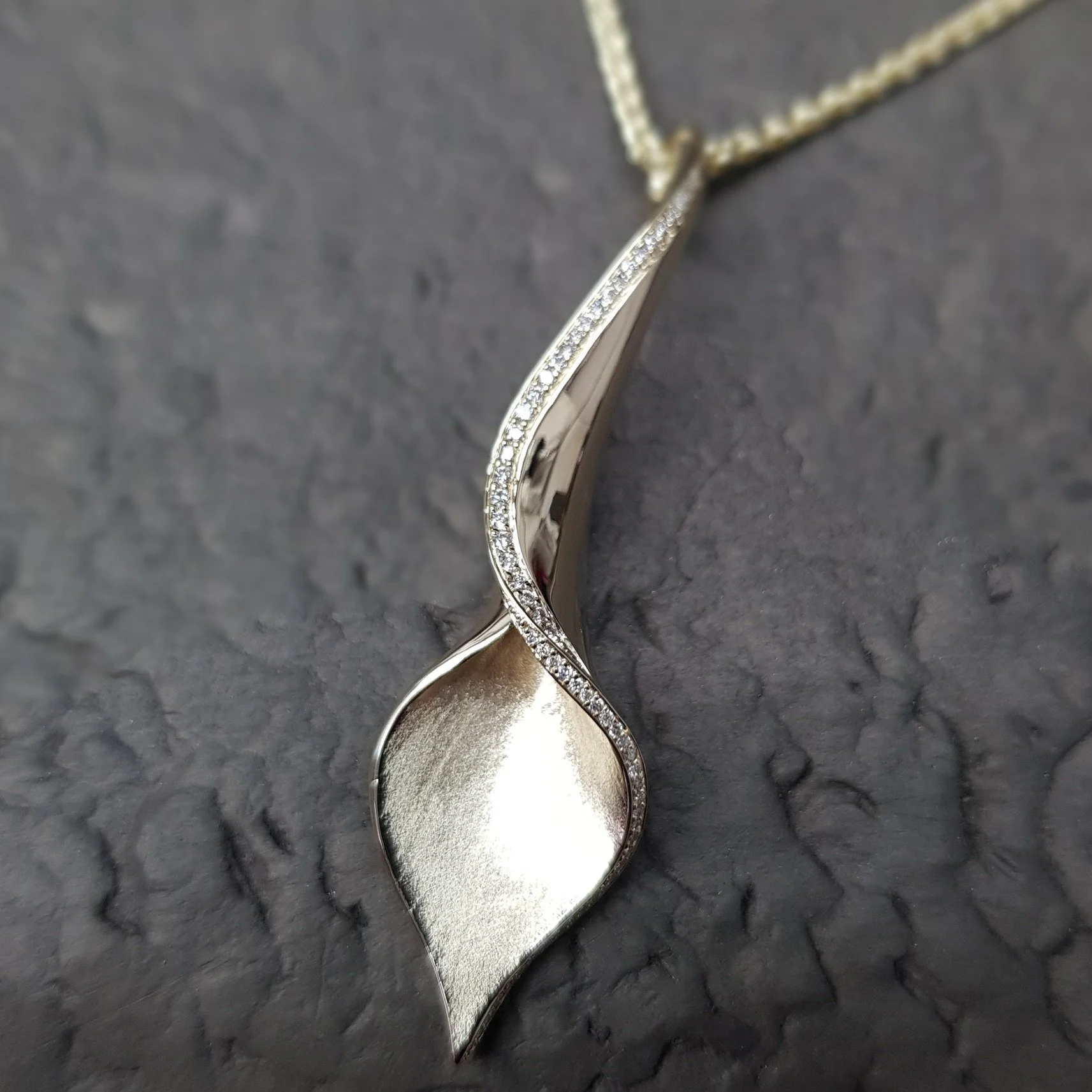 A classic Lilly pendant in 9ct yellow gold with a twist - as a one off to celebrate our 40th birthday this year, we've set this pendant with a stunning row of diamonds which just goes to accentuate the amazing sweep and curve of this Simon Pure  desi
