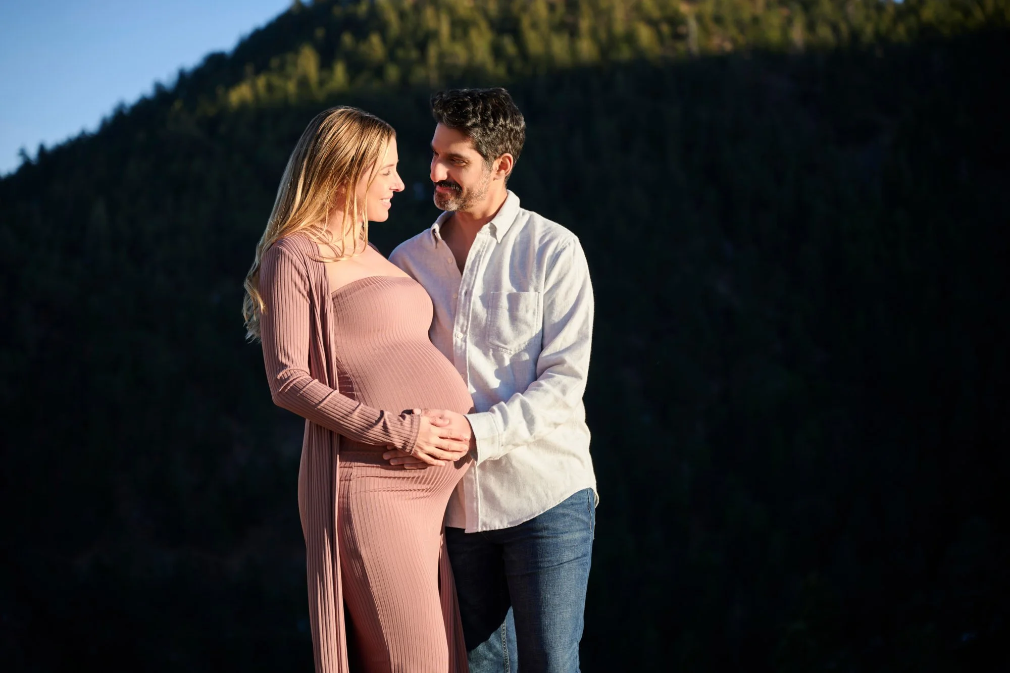 Golden light on an expecting couple in the foothills near Denver, Colorado, photographed by Ethan Herrold.
