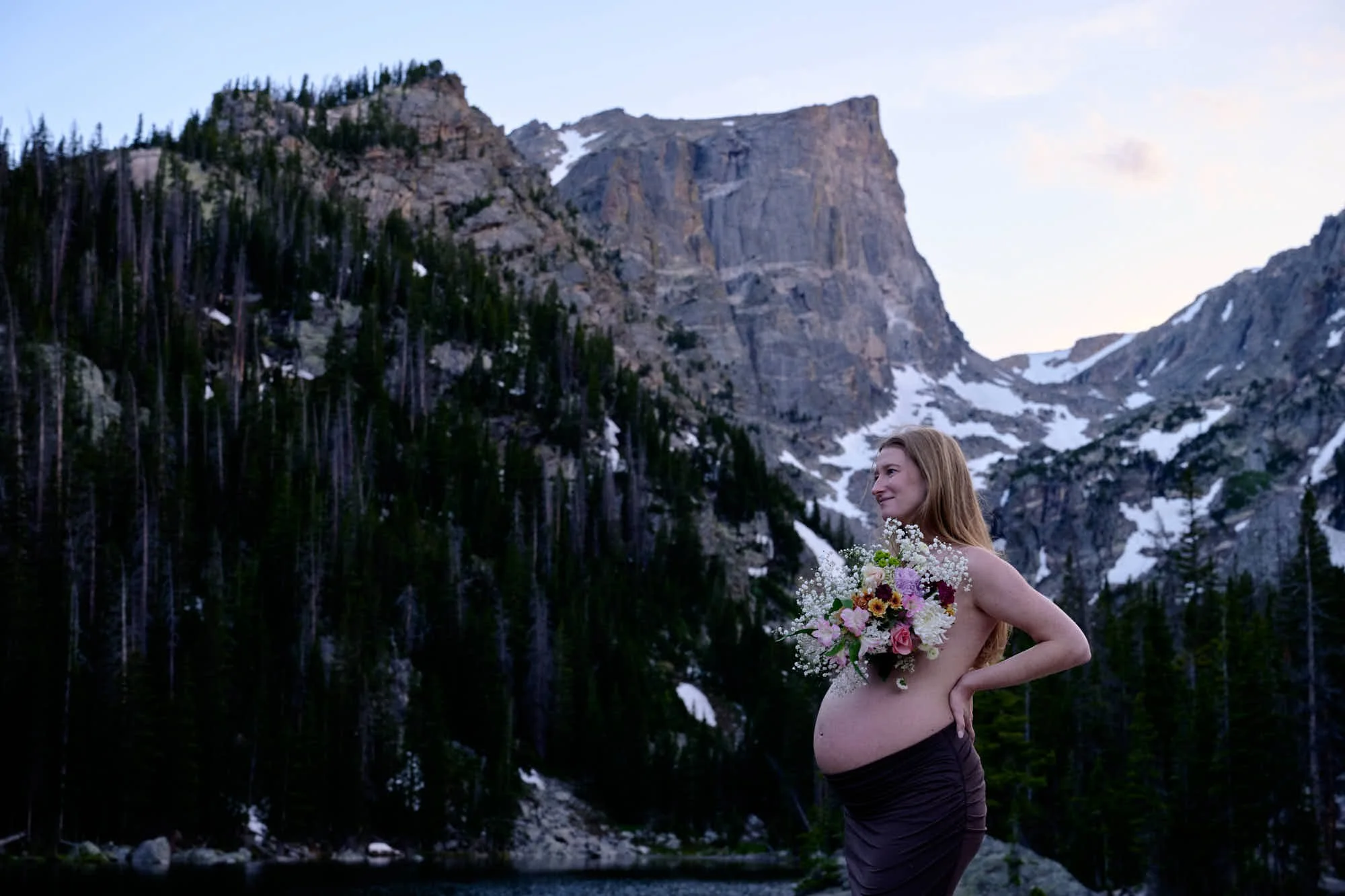 Expecting mother beneath Hallett Peak at Dream Lake in Rocky Mountain National Park at sunset.