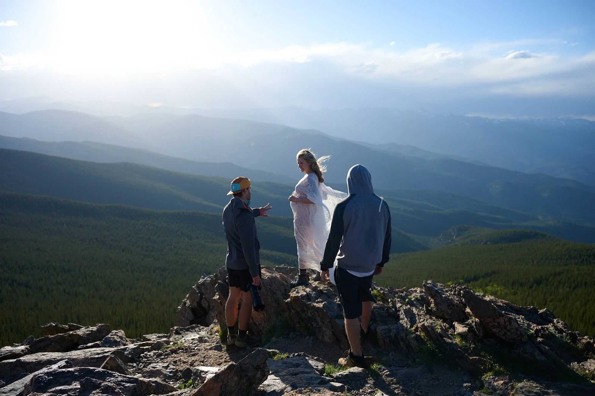 Ethan Herrold directs an adventure maternity session on a rocky summit, telephoto in hand.