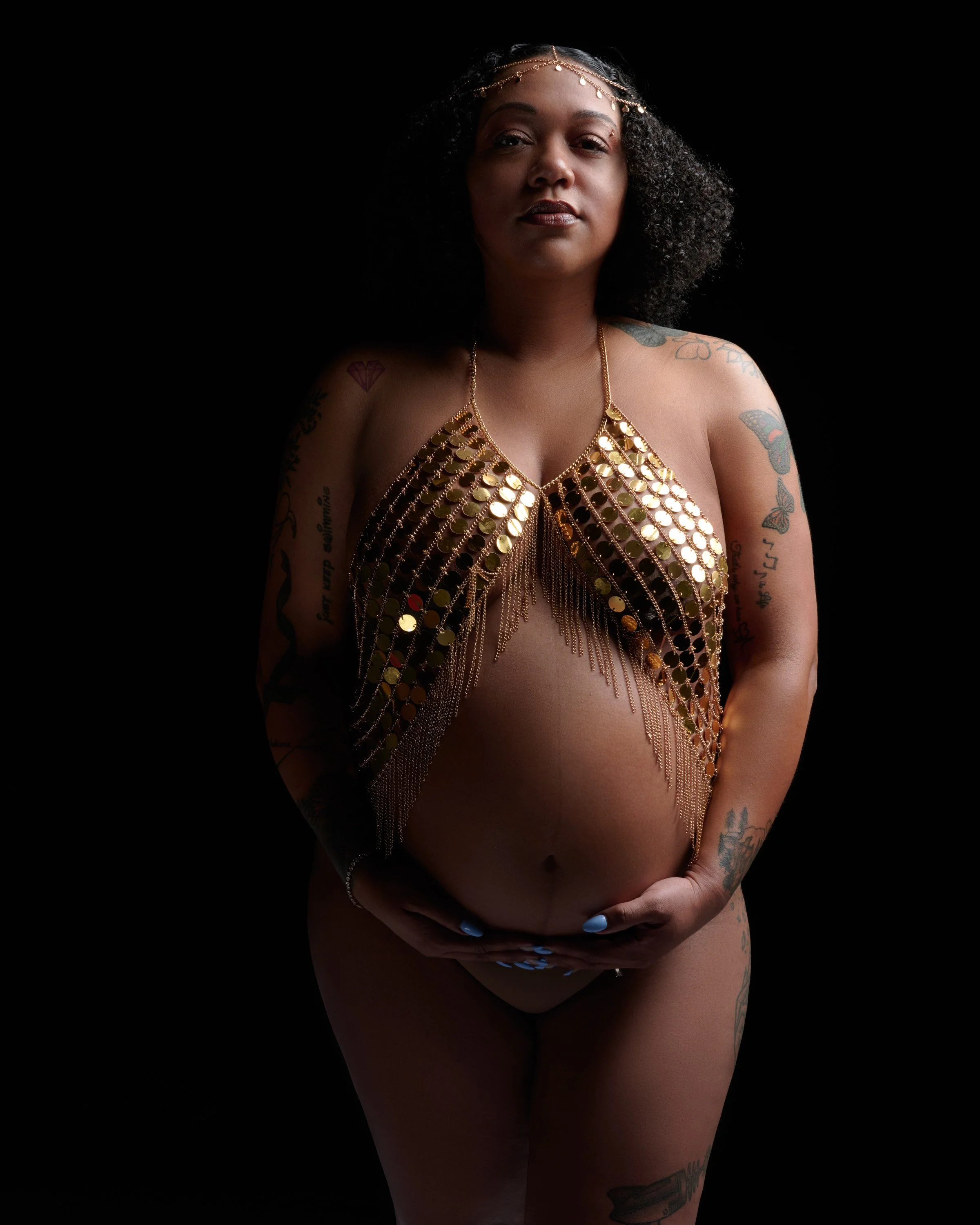Gold coin body chain and head chain, regal against black.