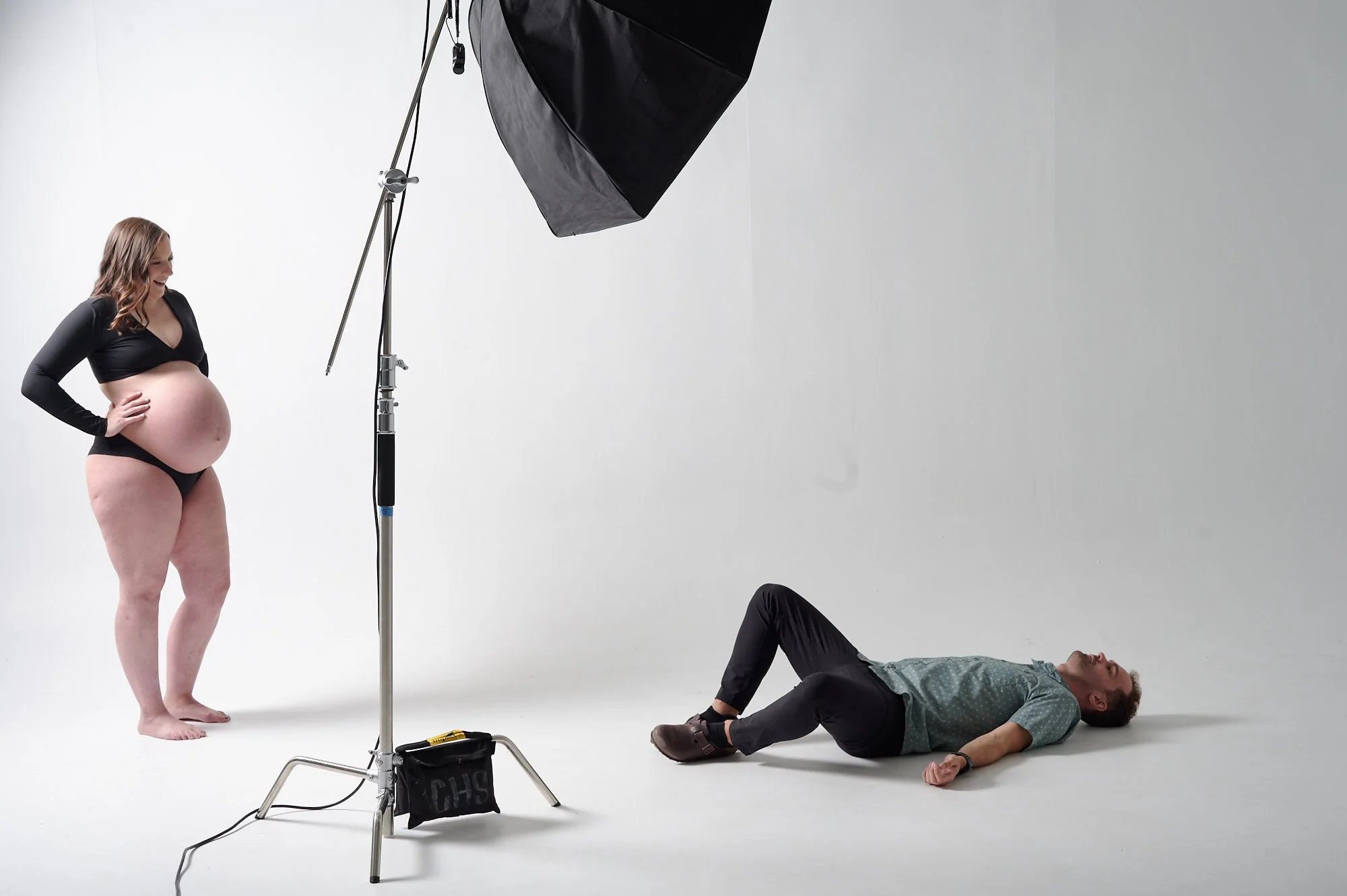 Workshop demo: shooting from the floor beneath a posed mother on white.