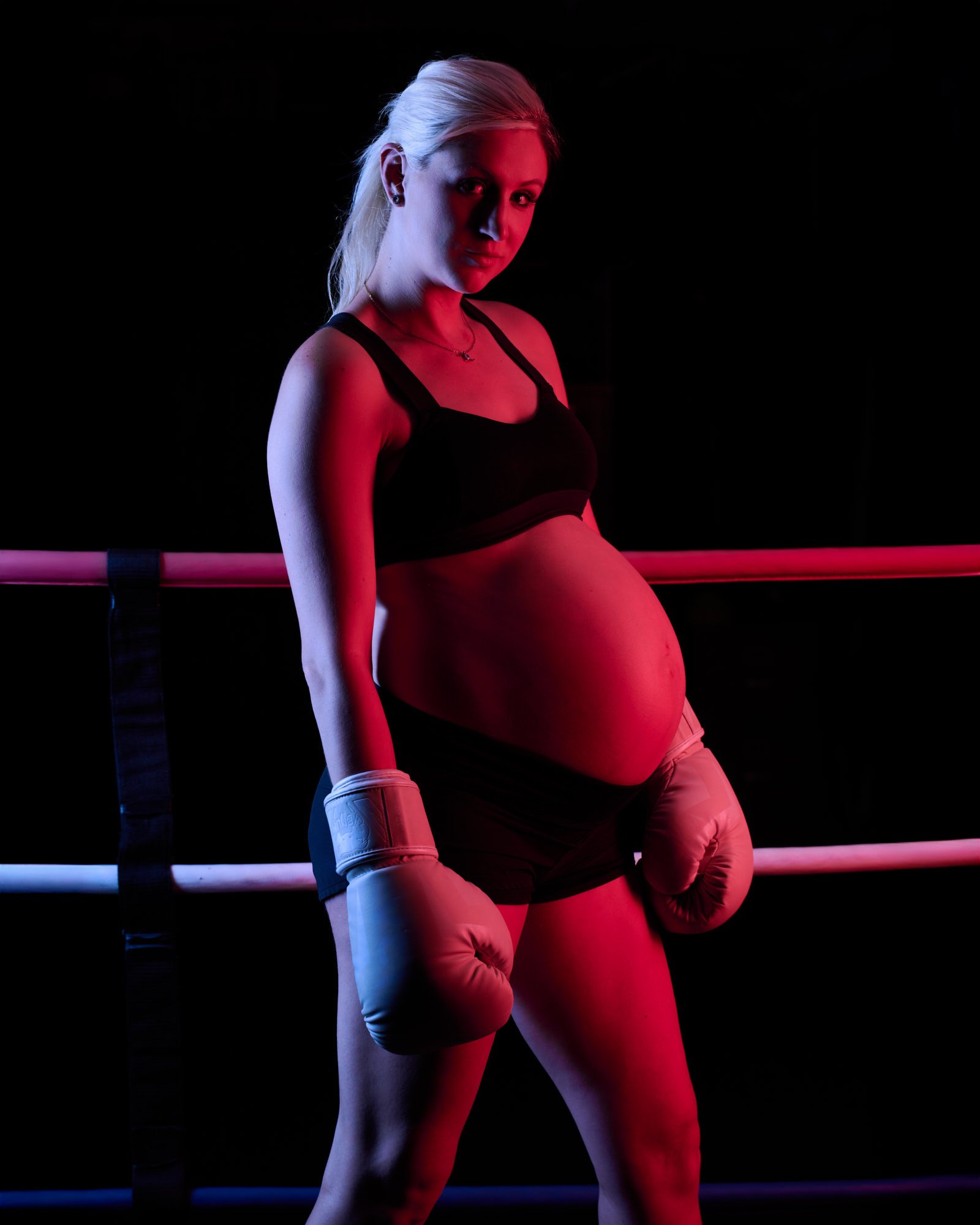 Standing against the ropes in profile, blue and red edges tracing the bump.