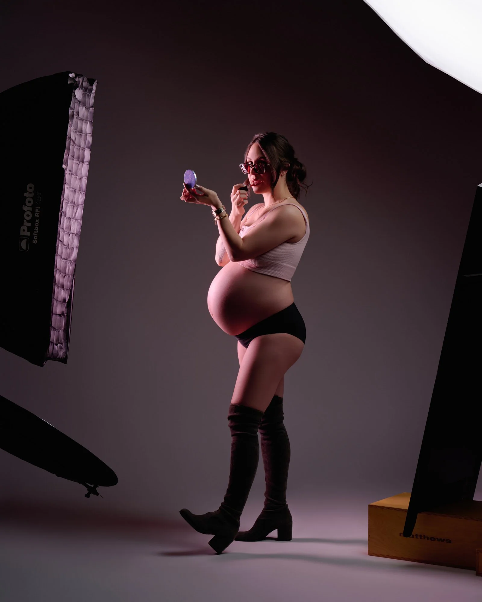 Behind the scenes with studio strobes in frame, tall boots and a camera remote.