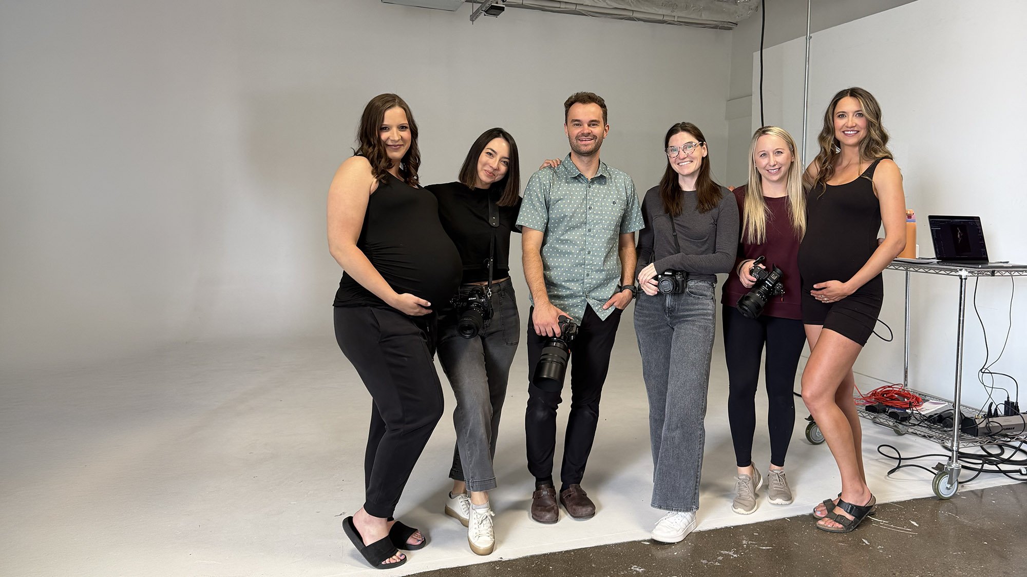 Ethan Herrold at his maternity photo workshop with expecting clients in the Denver studio, cameras in hand.